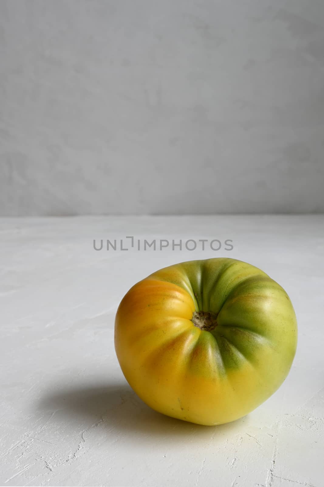 yellow green tomat on a white background.