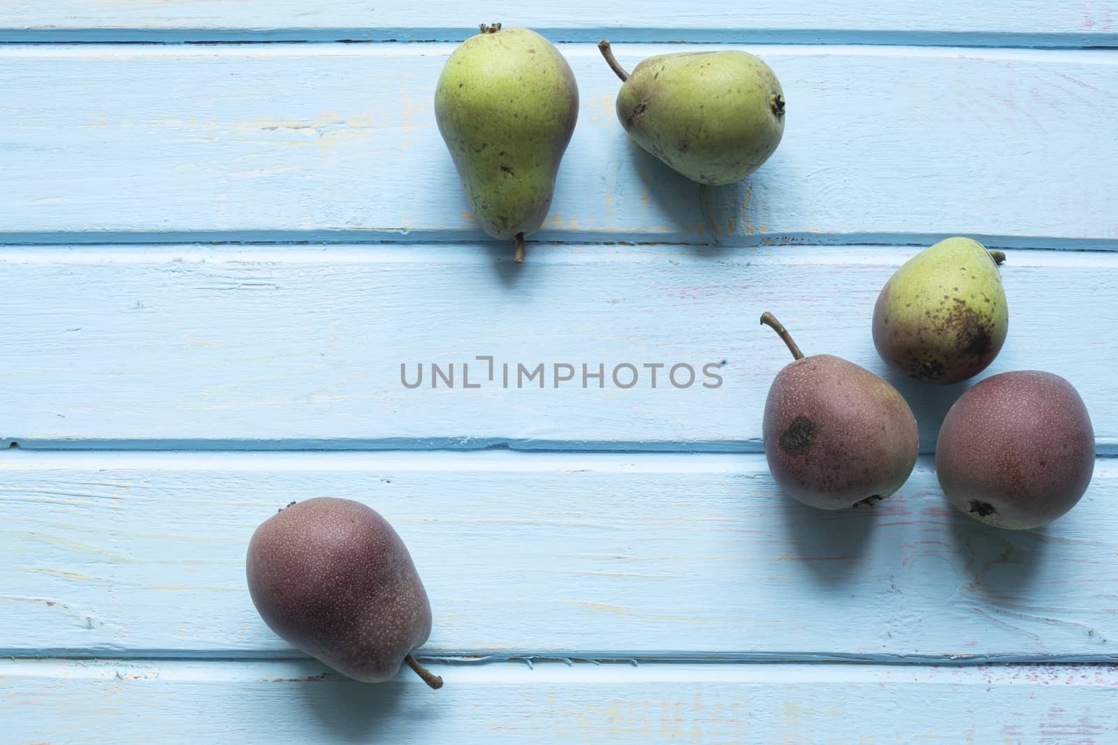 Halves of fresh ripe pears on wooden background.