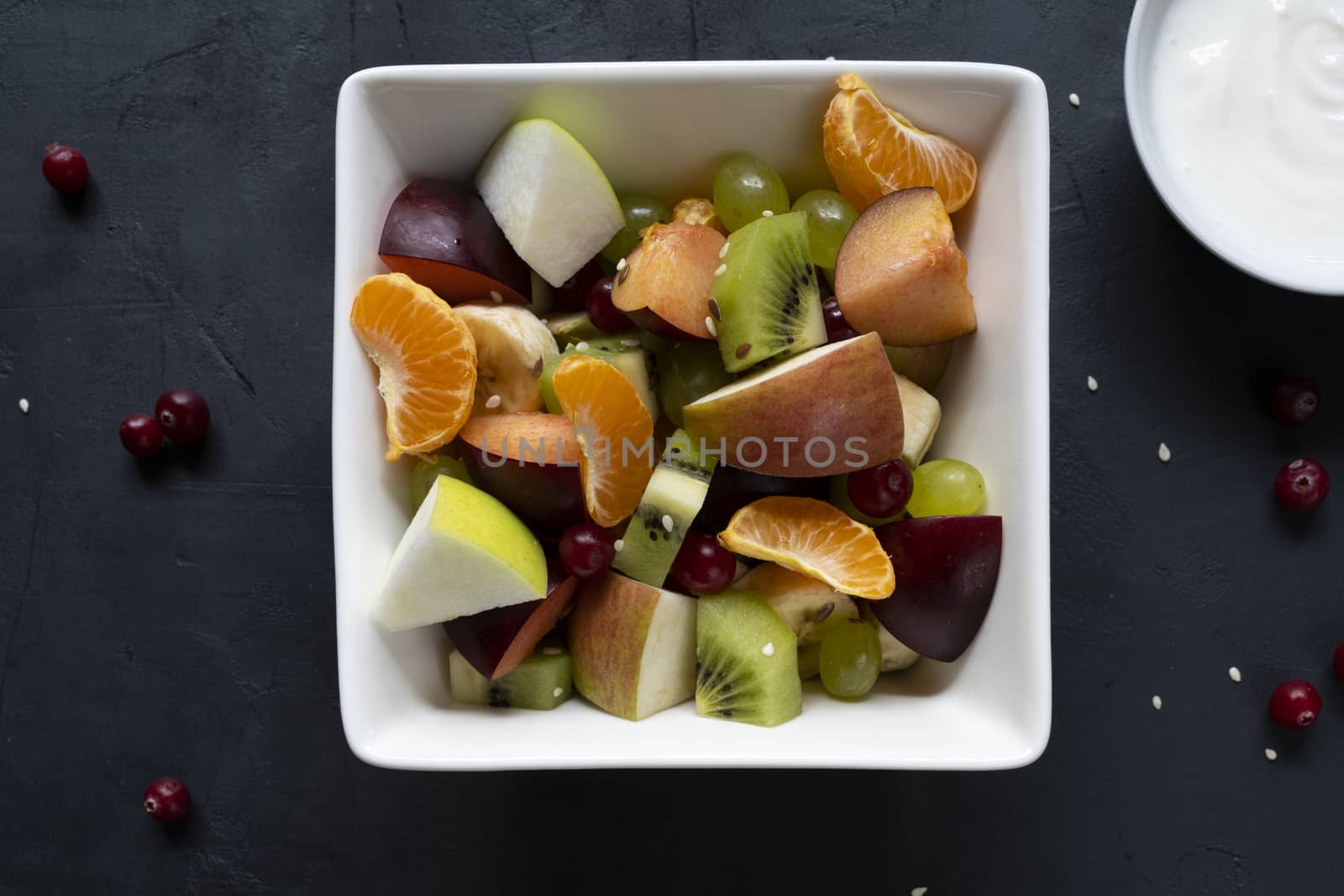 healthy salad from fresh fruit on a dark table.