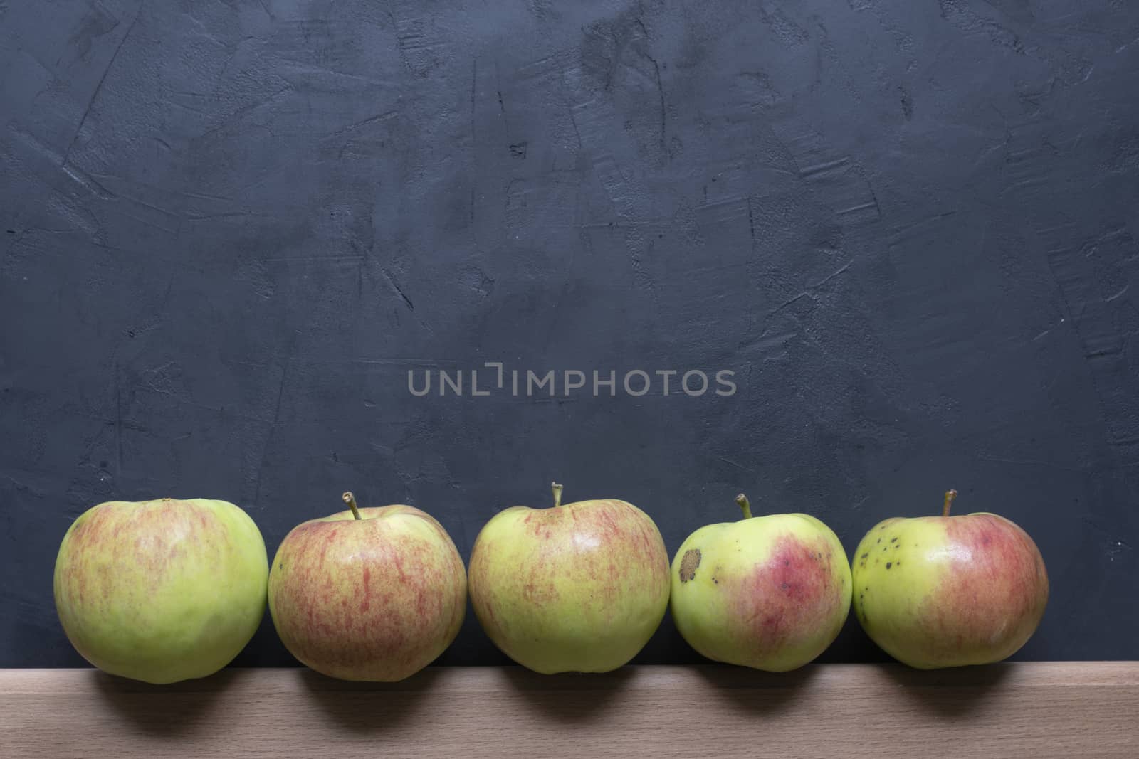 green and red apples on a black background.