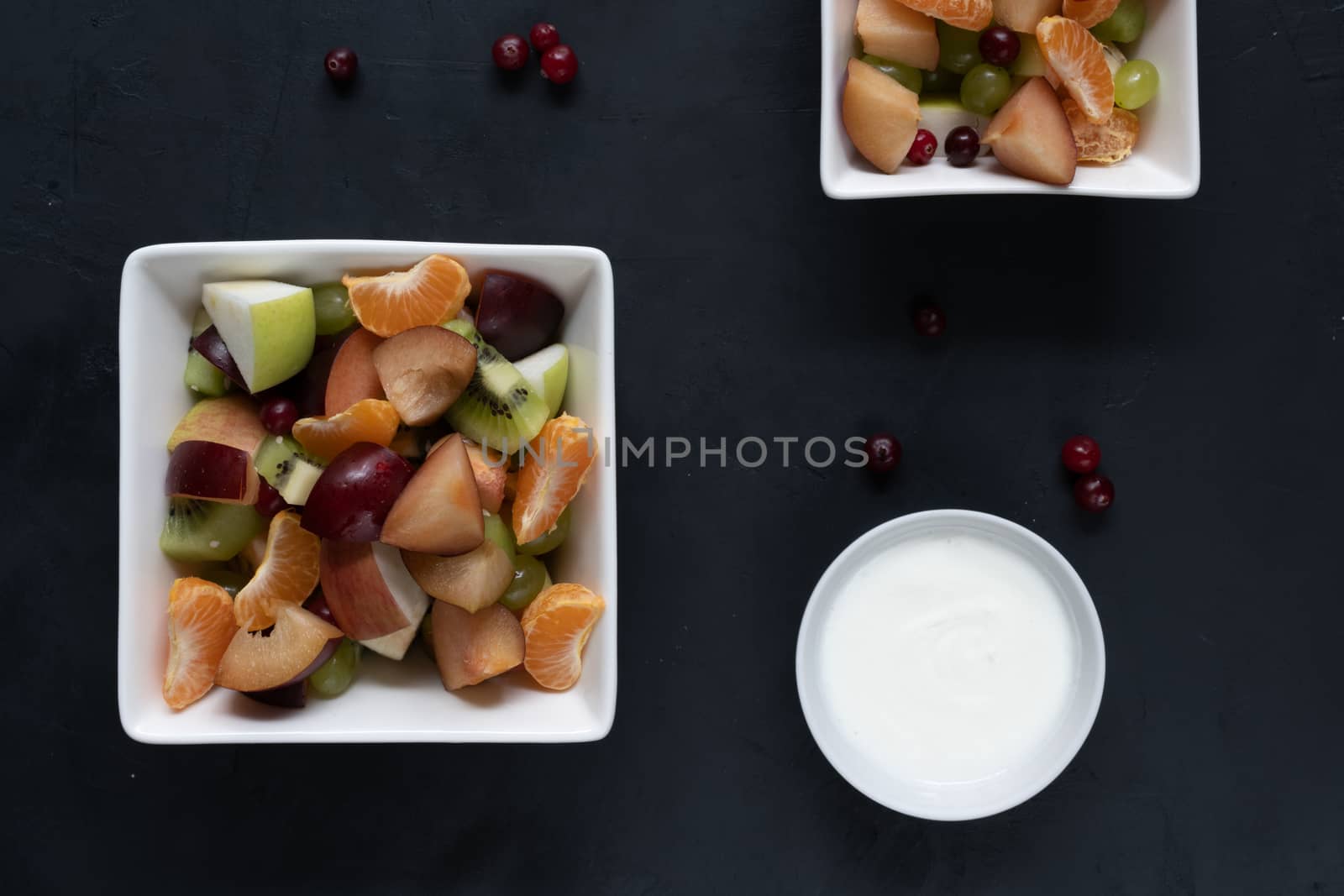 healthy salad from fresh fruit on a dark table by sashokddt