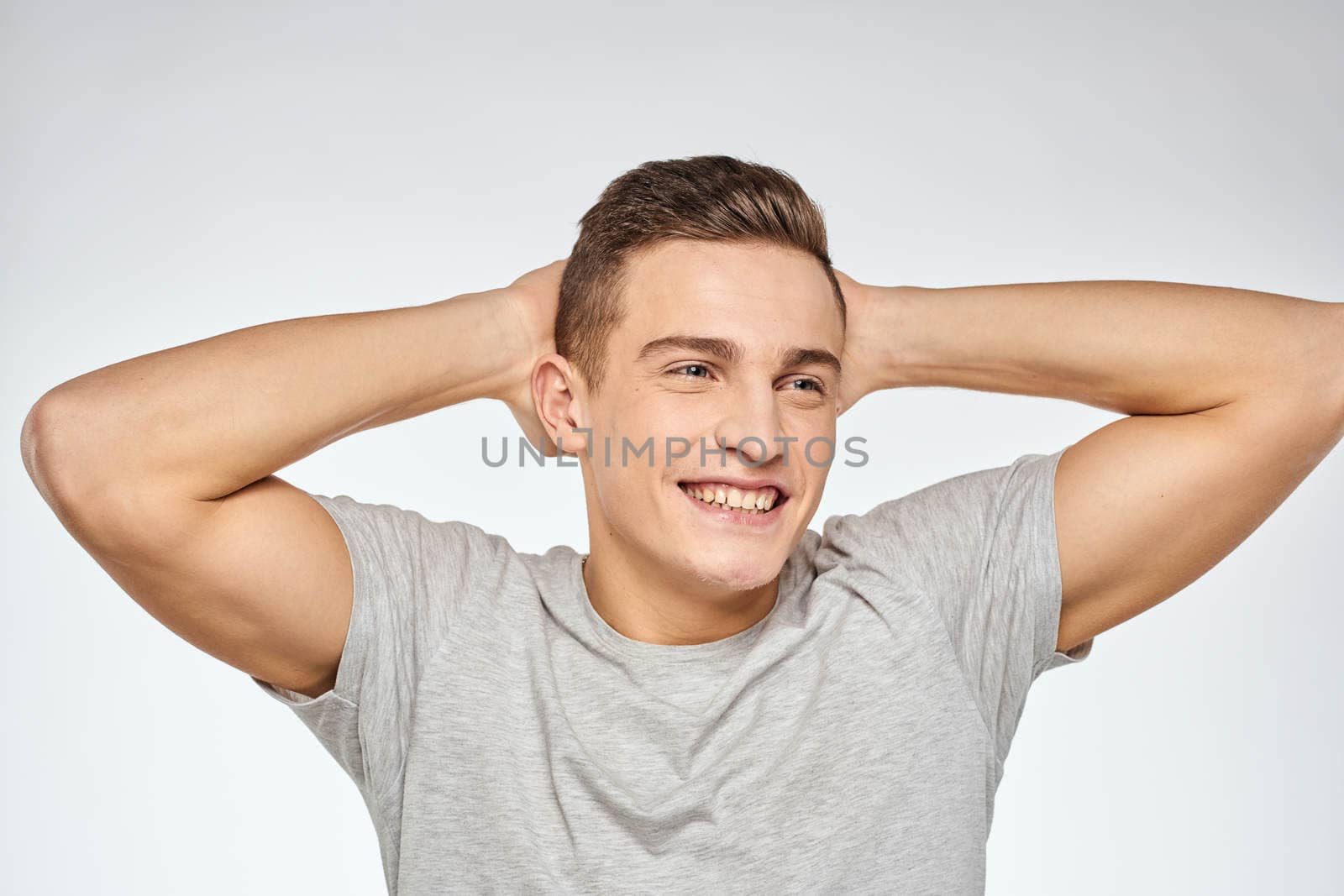 Cheerful emotional man gray t-shirt gesturing with hands studio lifestyle. High quality photo