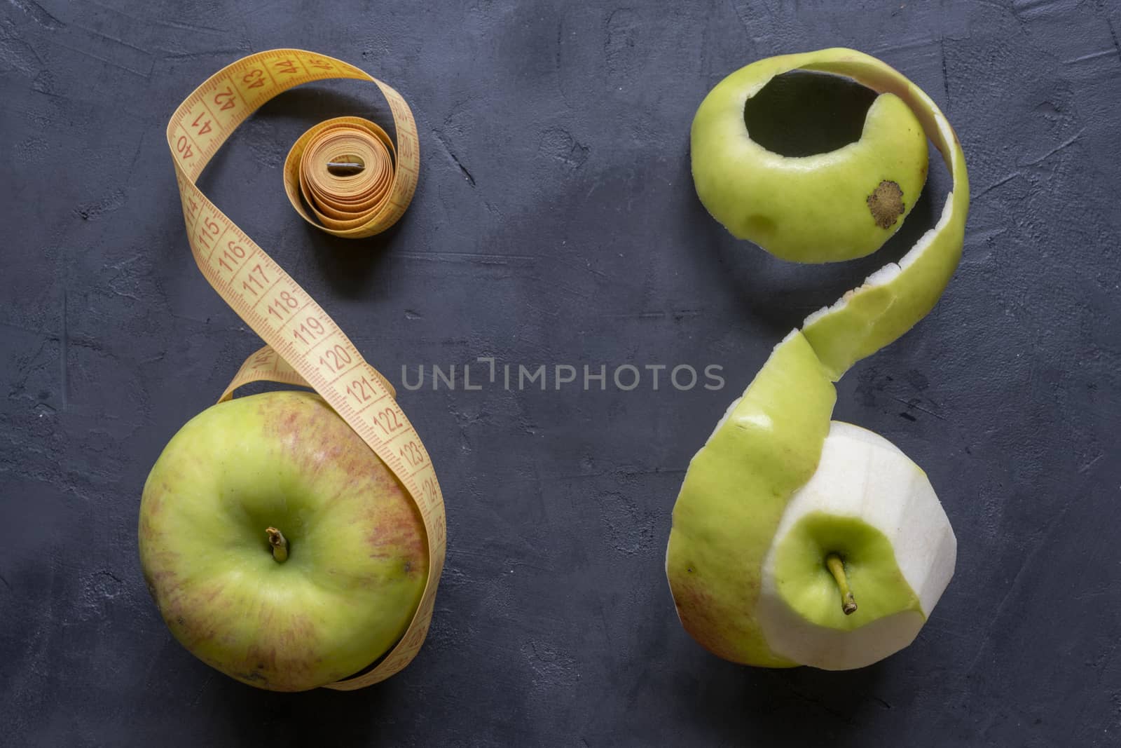 Piece of cut and peeled apple, peels and seeds, on black background by sashokddt