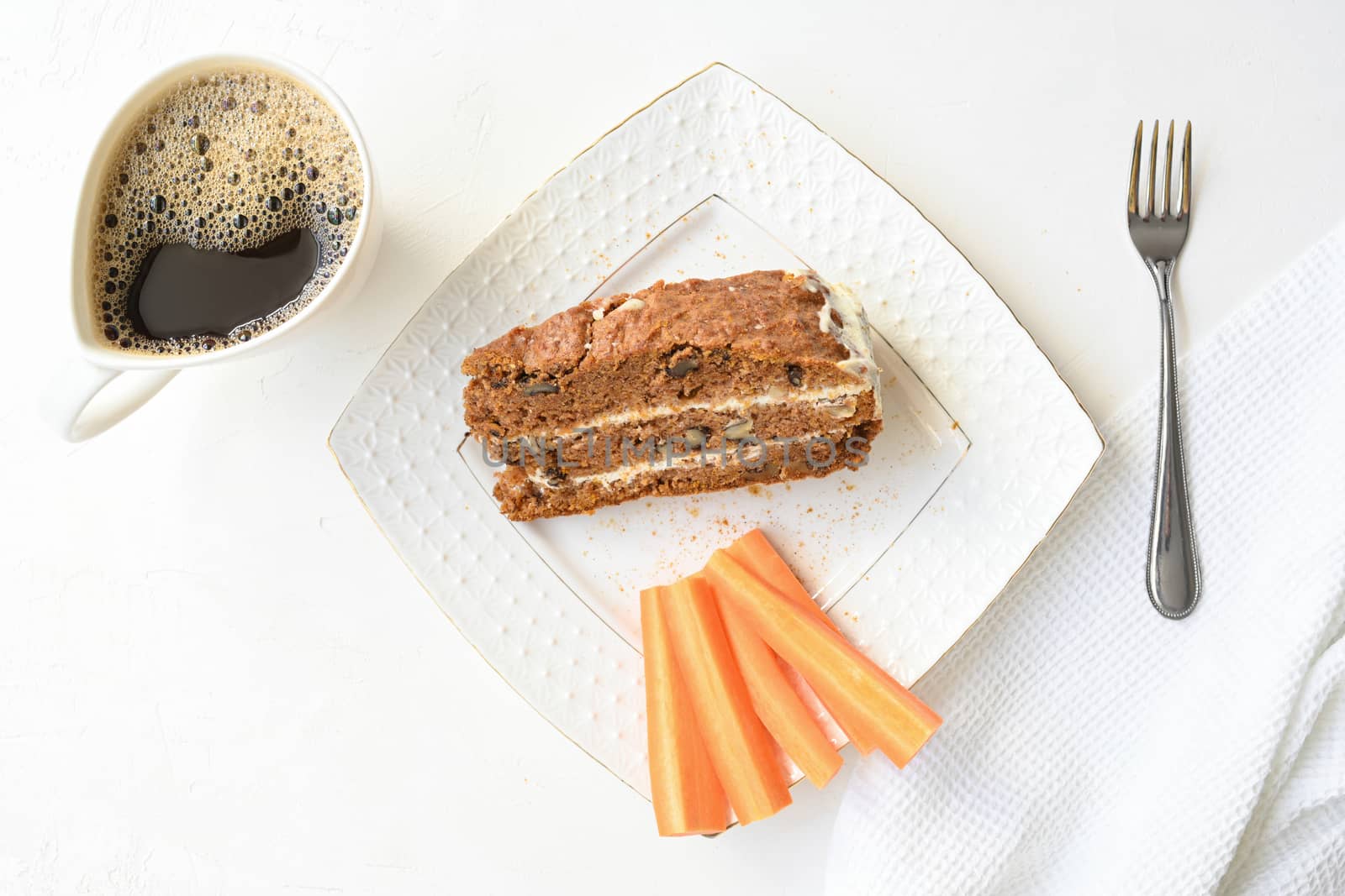 Slice of carrot cake and coffee on white background.