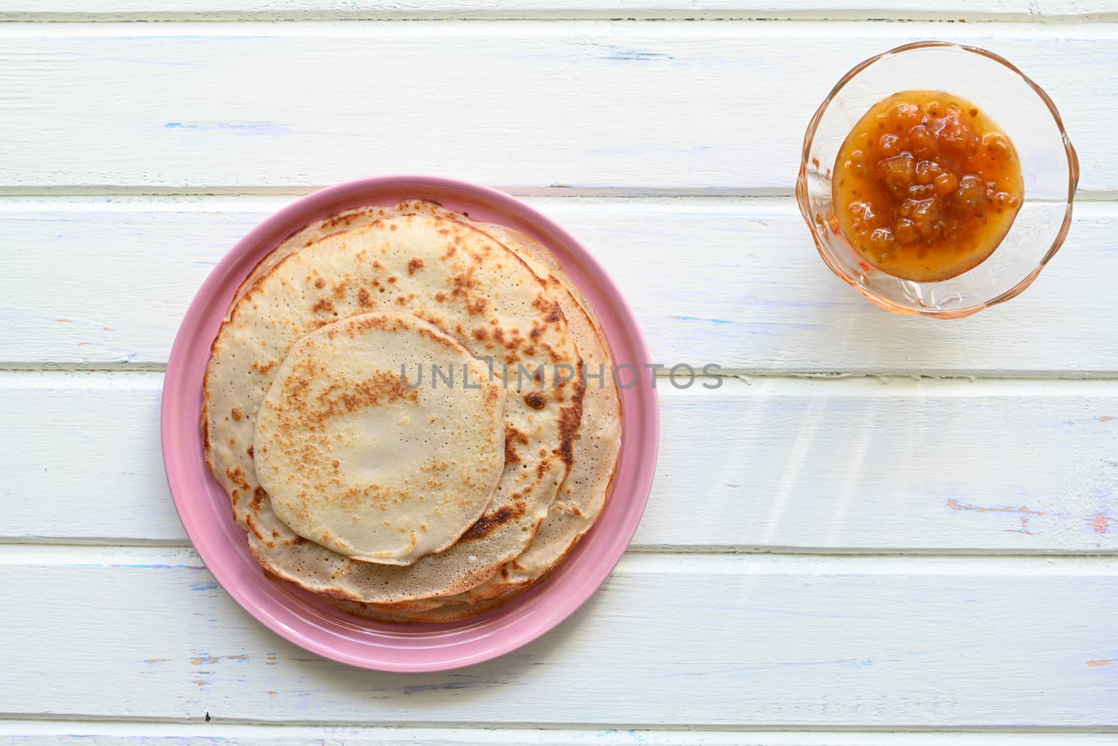 large pancakes with jam on white background