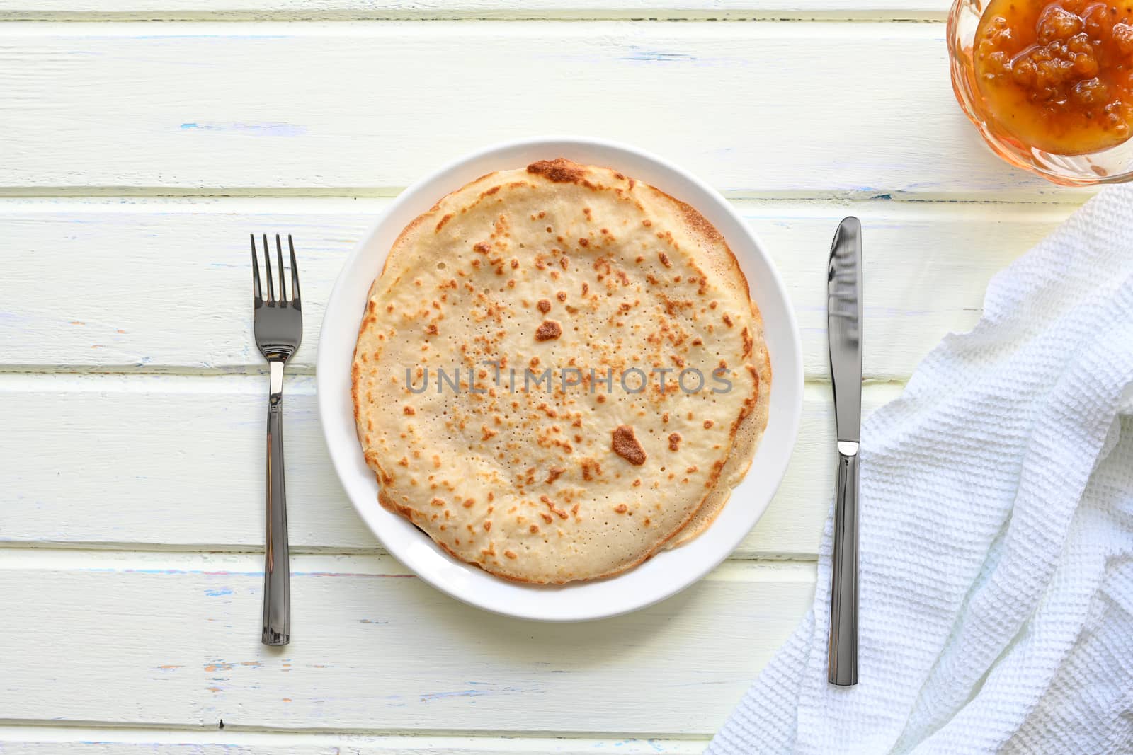 large pancakes with jam on white background