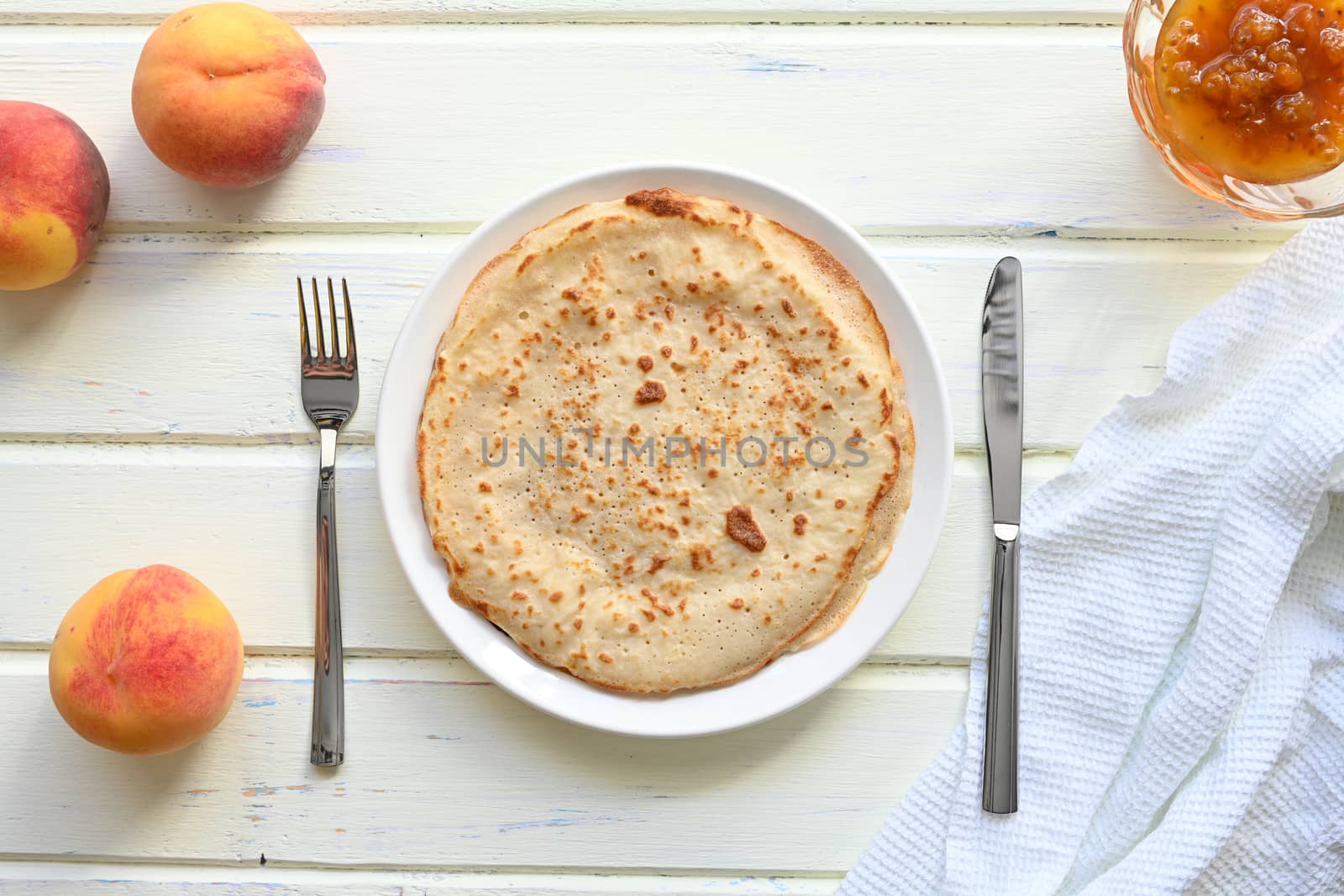 large pancakes with jam on white background