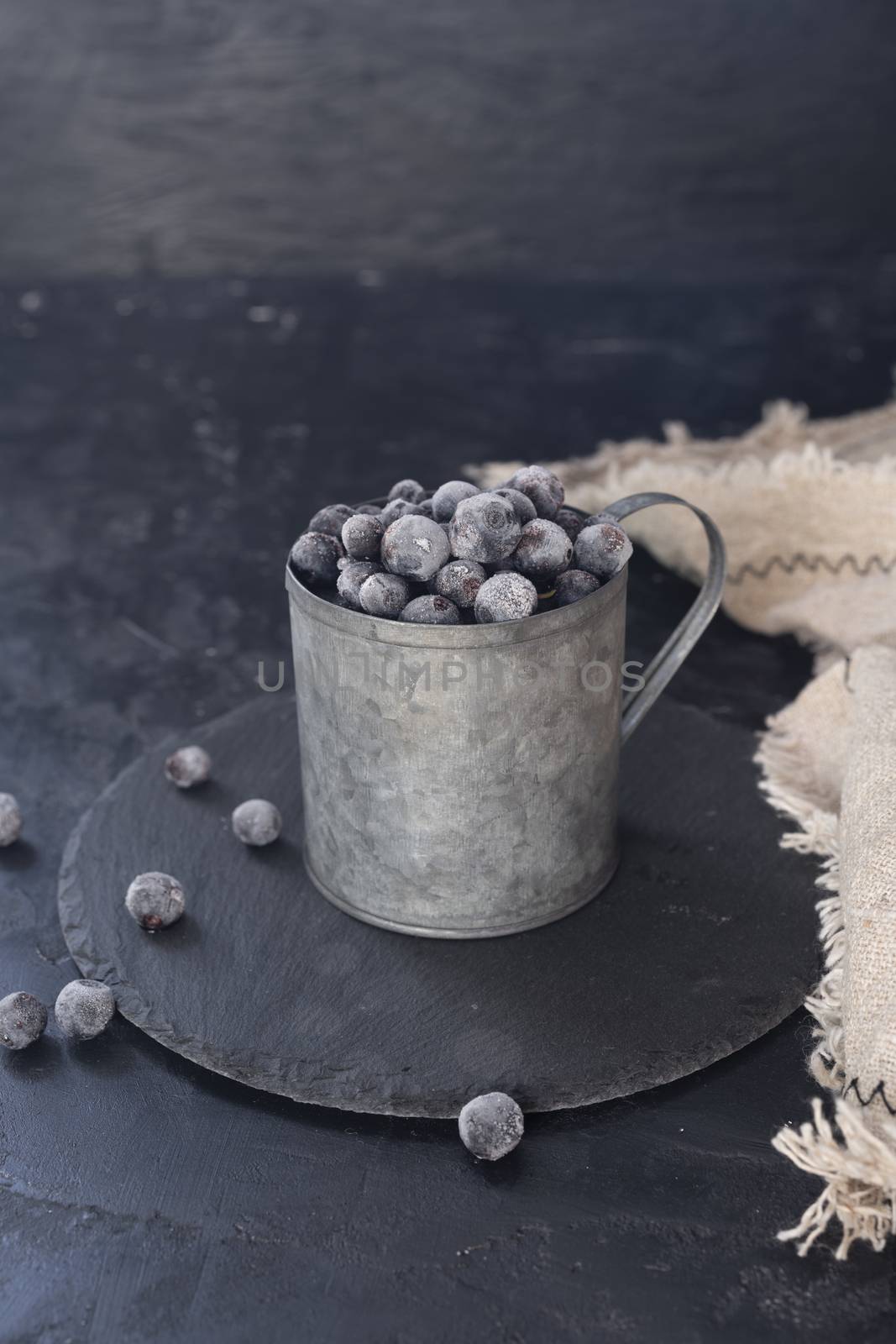 Photo of frozen blueberry in metal mug.