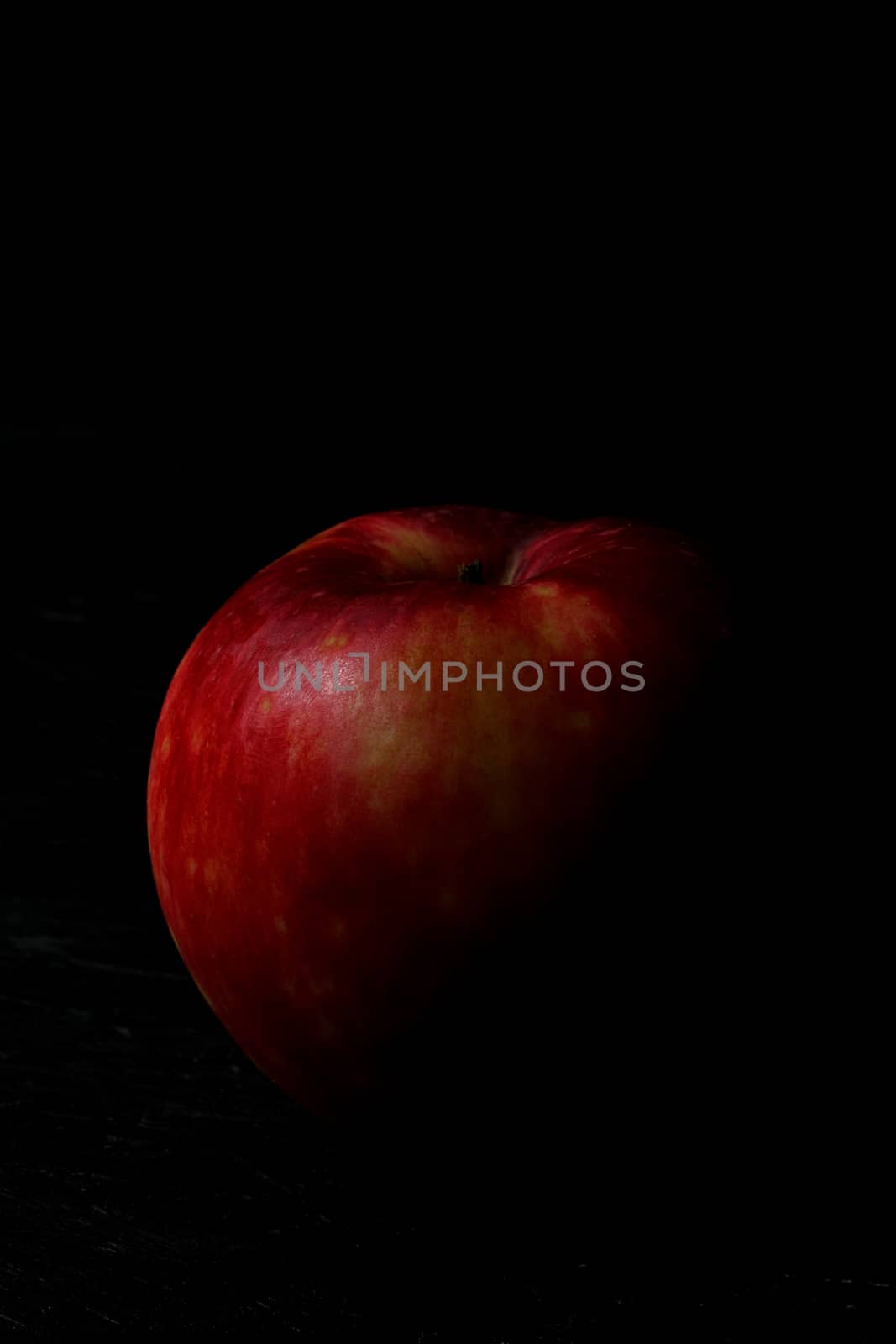 Red apple isolated on black wooden background