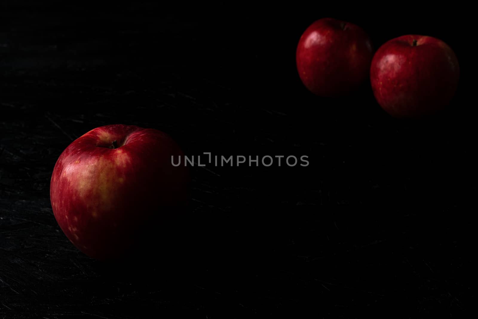 Red apple isolated on the black wooden background by sashokddt