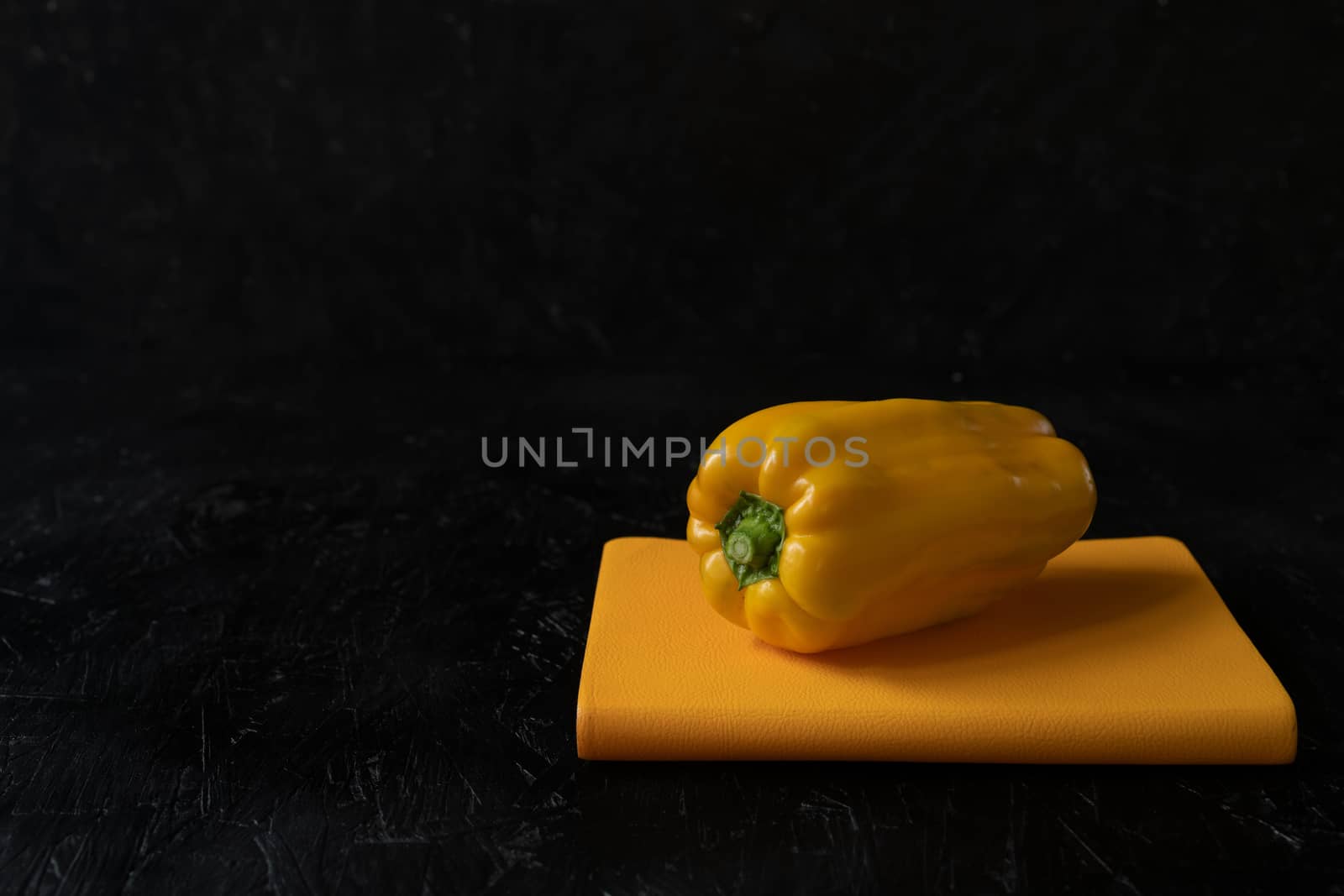 Image of yellow raw pepper on the black background
