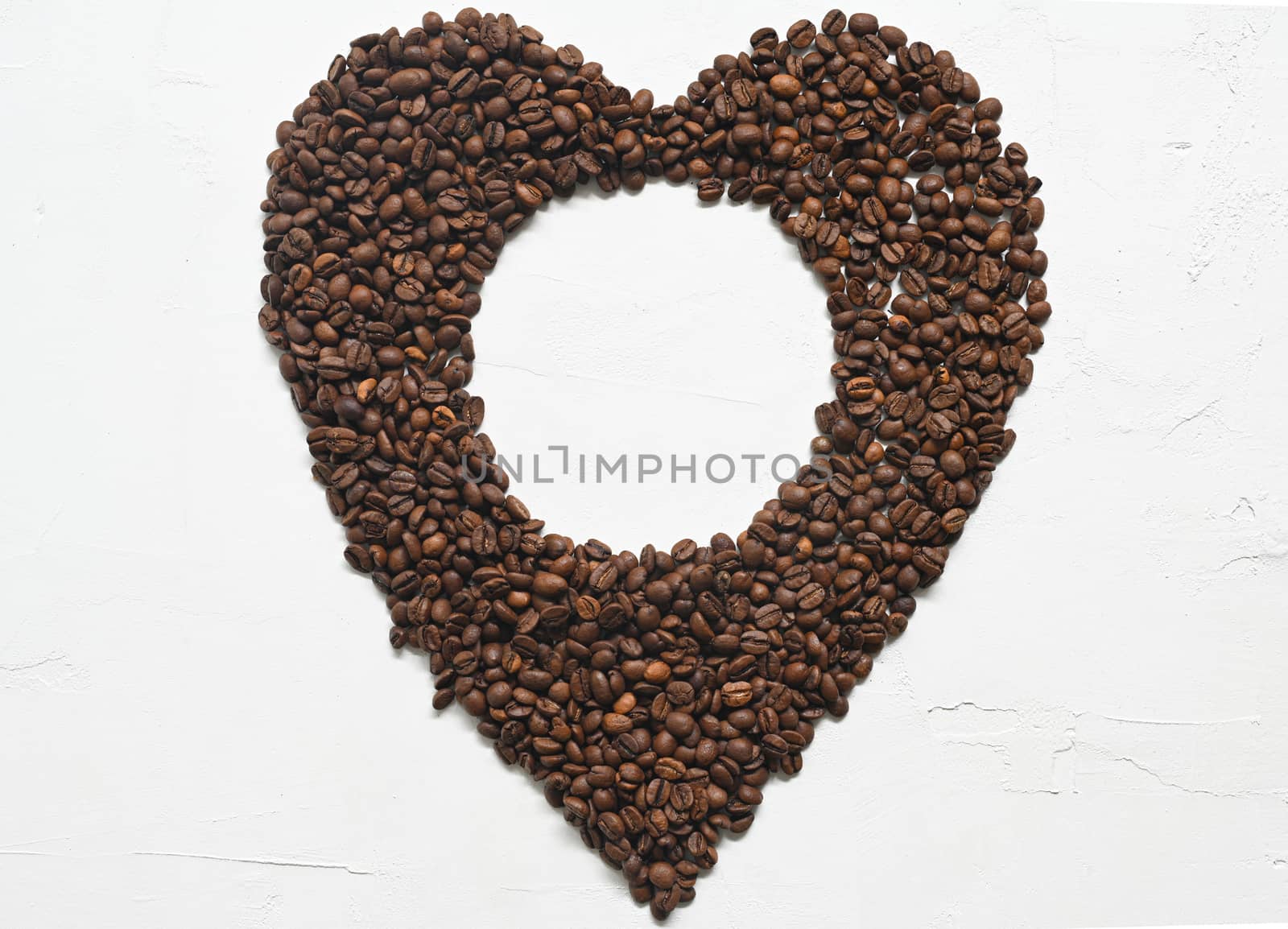 Heart made out of coffee beans on white background by sashokddt