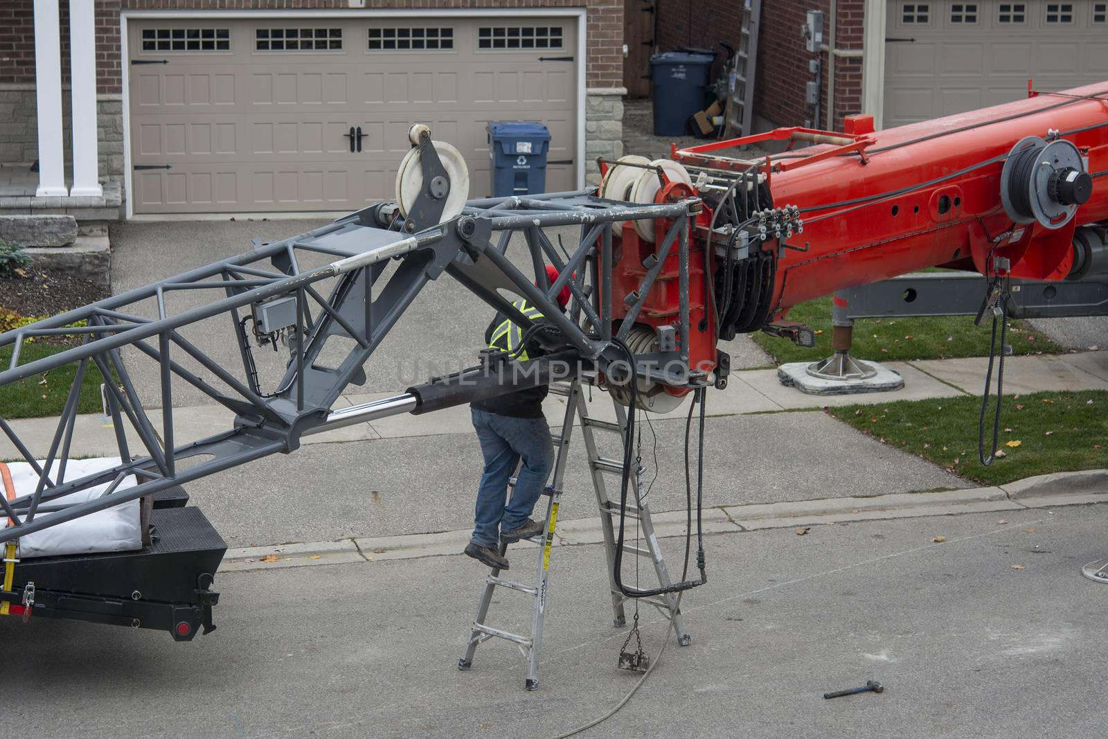 The crane operator prepares the crane for work, attaches an additional section by extending the boom