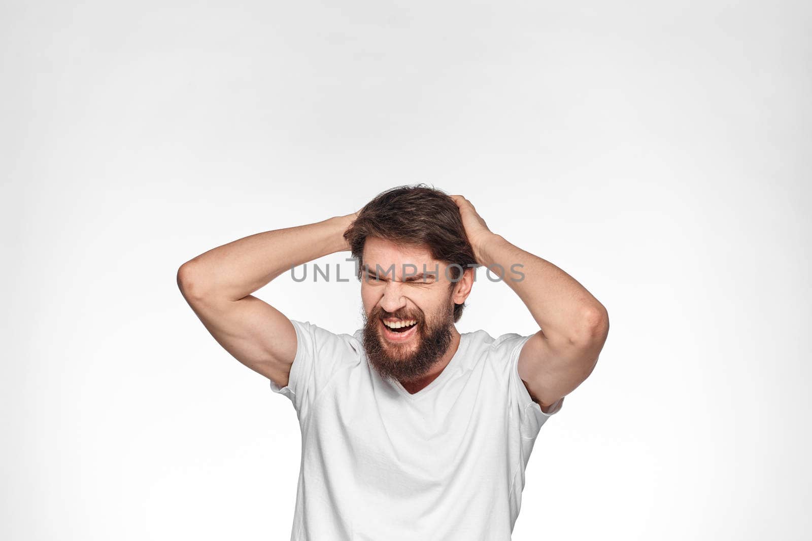 cheerful emotional bearded man gesturing with his hands close-up light background. High quality photo