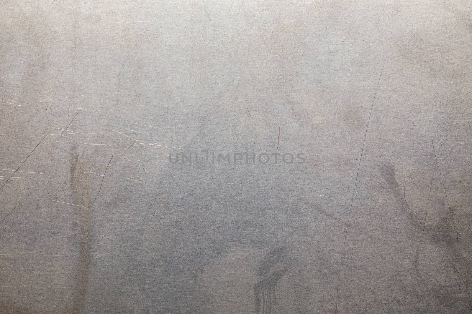 Uncoated flat cold rolled metal sheet surface with minor scratches. Close-up in directly above composition.