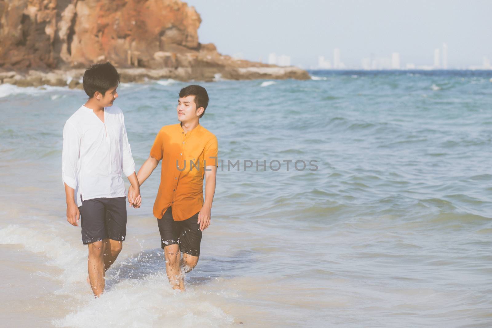 Homosexual portrait young asian couple walking with cheerful together on beach in summer, asia gay going tourism for leisure and relax with happiness in vacation at sea, LGBT legal concept.