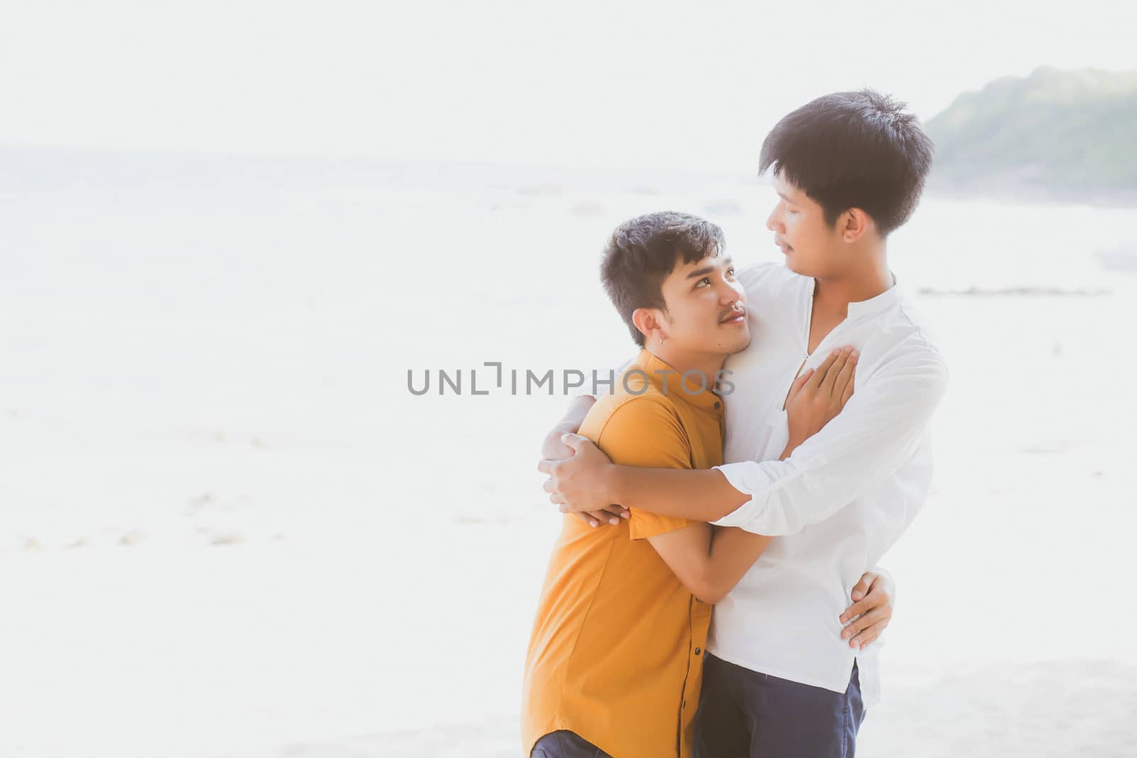 Homosexual portrait young asian couple standing hug together on beach in summer, asia gay going tourism for leisure and relax with romantic and happiness in vacation at sea, LGBT concept.