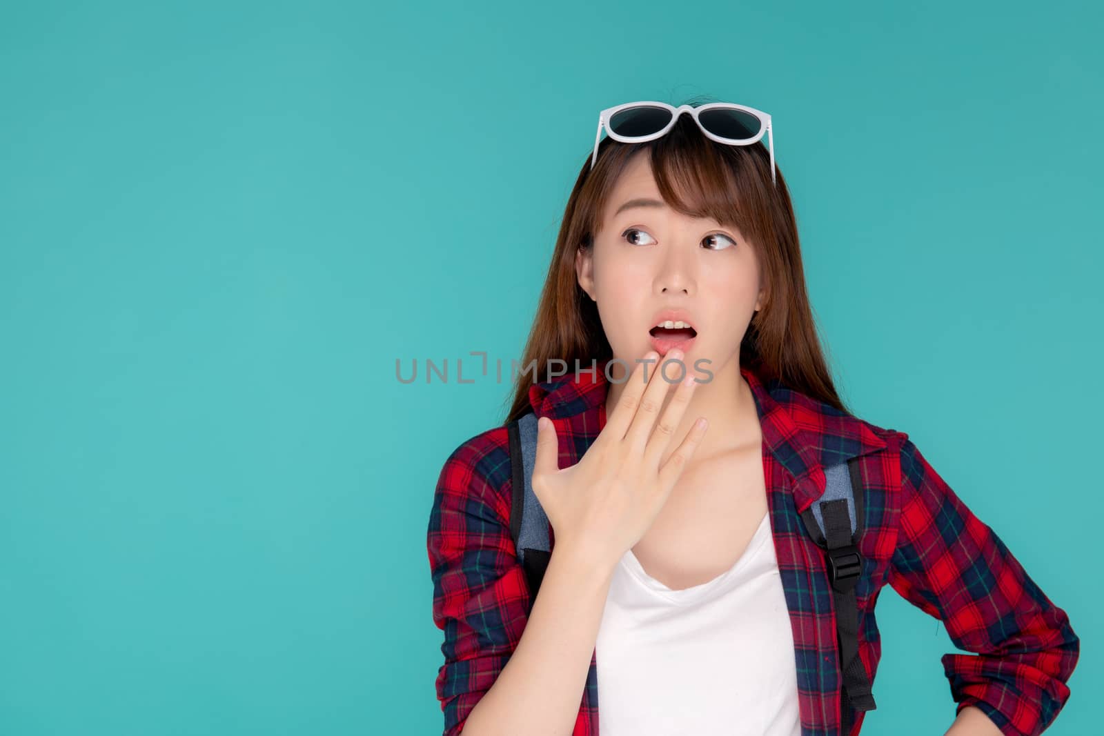 Beautiful portrait young asian woman surprise wearing travel summer fashion with tourist in vacation isolated on blue background, girl shocked expression and emotion, holiday amazing concept.