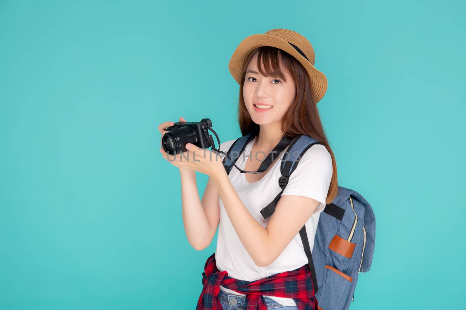 Beautiful young asian woman cheerful and enjoy travel trip summer isolated on blue background, asia girl having activity hobby take a photo holding camera, tourist journey in vacation and holiday.