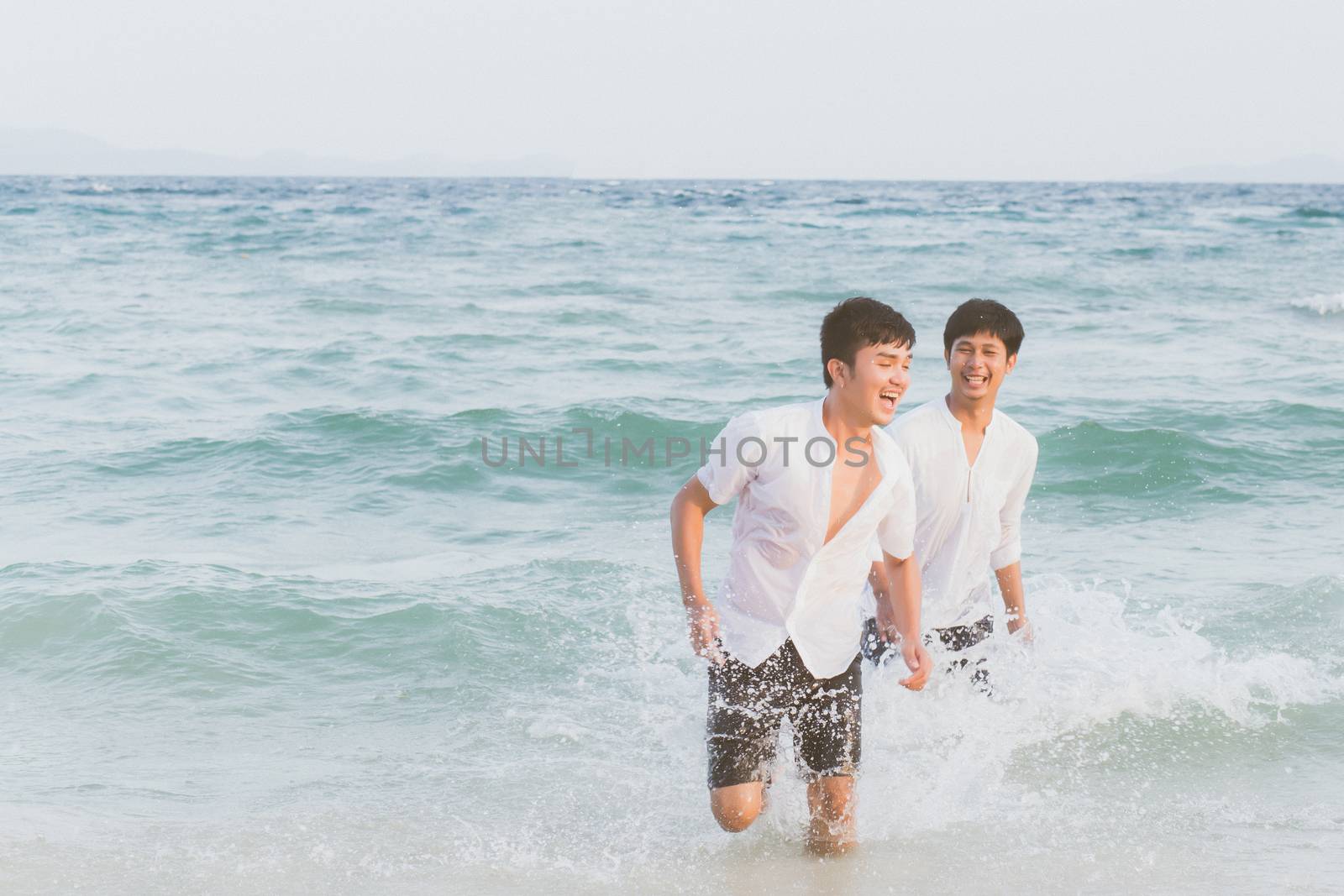 Homosexual portrait young asian couple running with cheerful together on beach in summer, asia gay going tourism for leisure and relax with happiness in vacation at sea, LGBT legal concept.