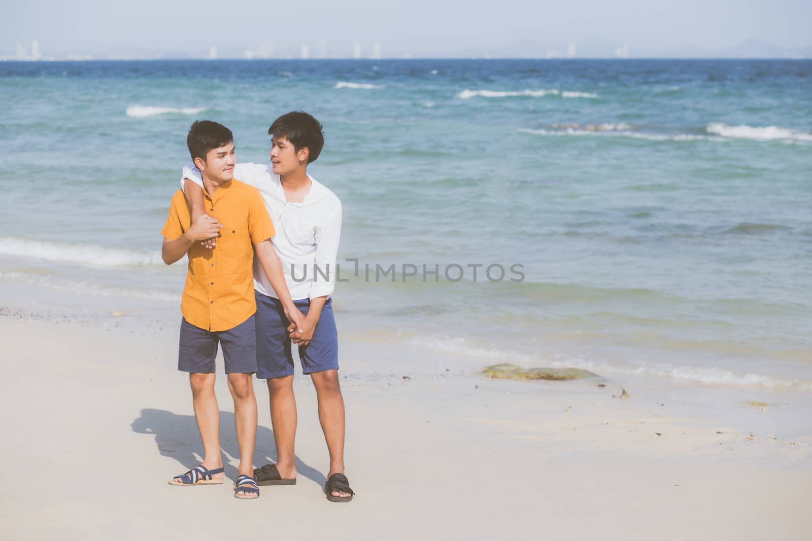 Homosexual portrait young asian couple standing hug together on  by nnudoo