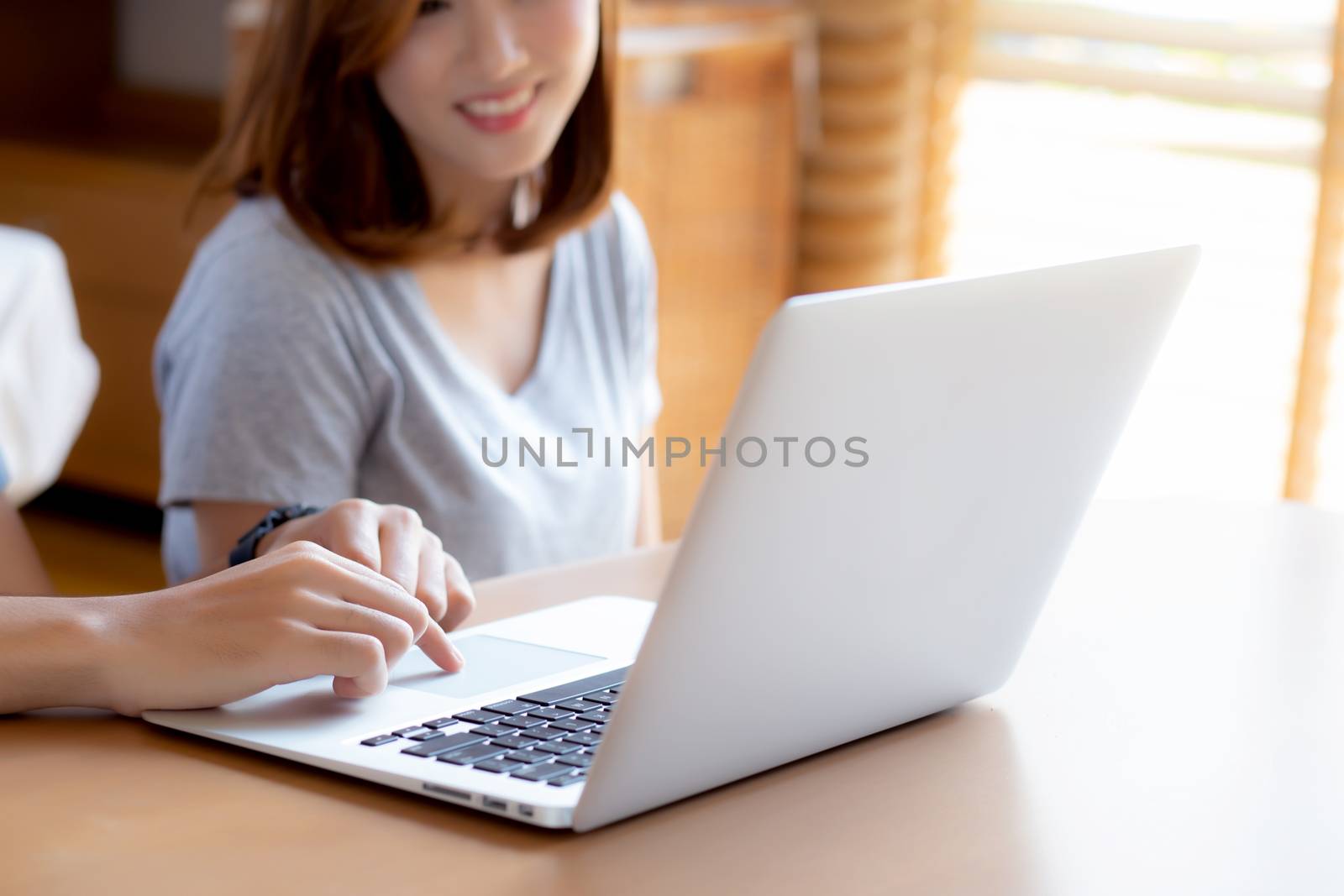 Asian young couple using laptop computer think and searching internet together, man and woman casual smiling work at home with happy and relax, communication and business concept.