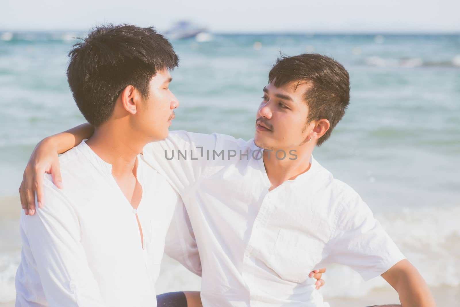 Homosexual portrait young asian couple sitting hug together on b by nnudoo