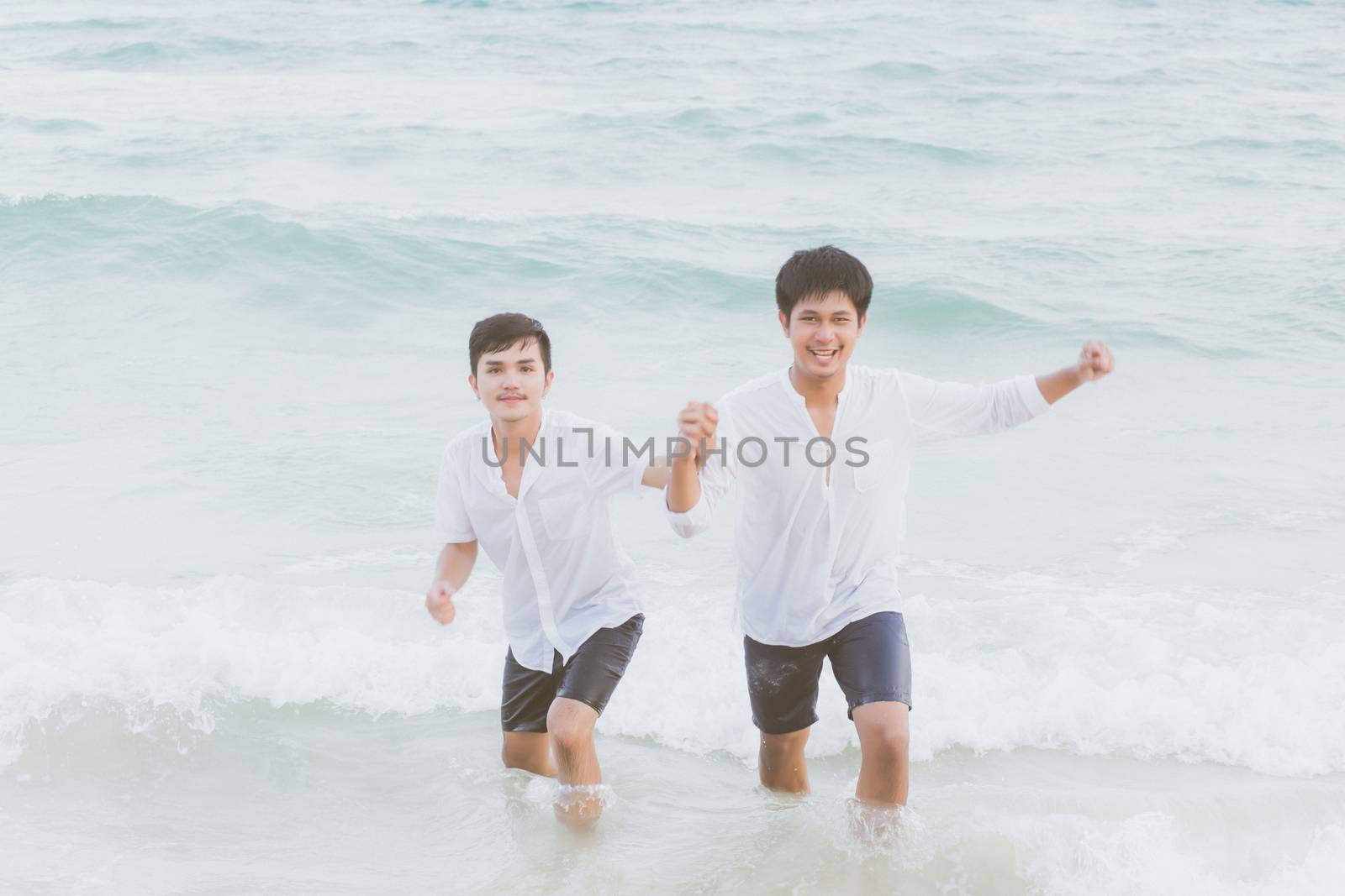 Homosexual portrait young asian couple running with cheerful together on beach in summer, asia gay going tourism for leisure and relax with happiness in vacation at sea, LGBT legal concept.