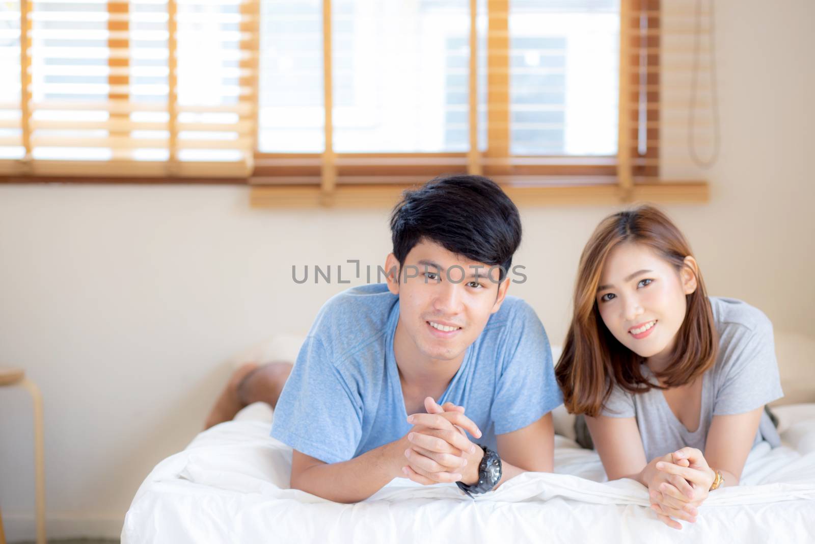 Beautiful portrait young asian couple relax and satisfied together in bedroom at home, family lying on bed confident with cheerful and happy with relationship, man and woman dating.