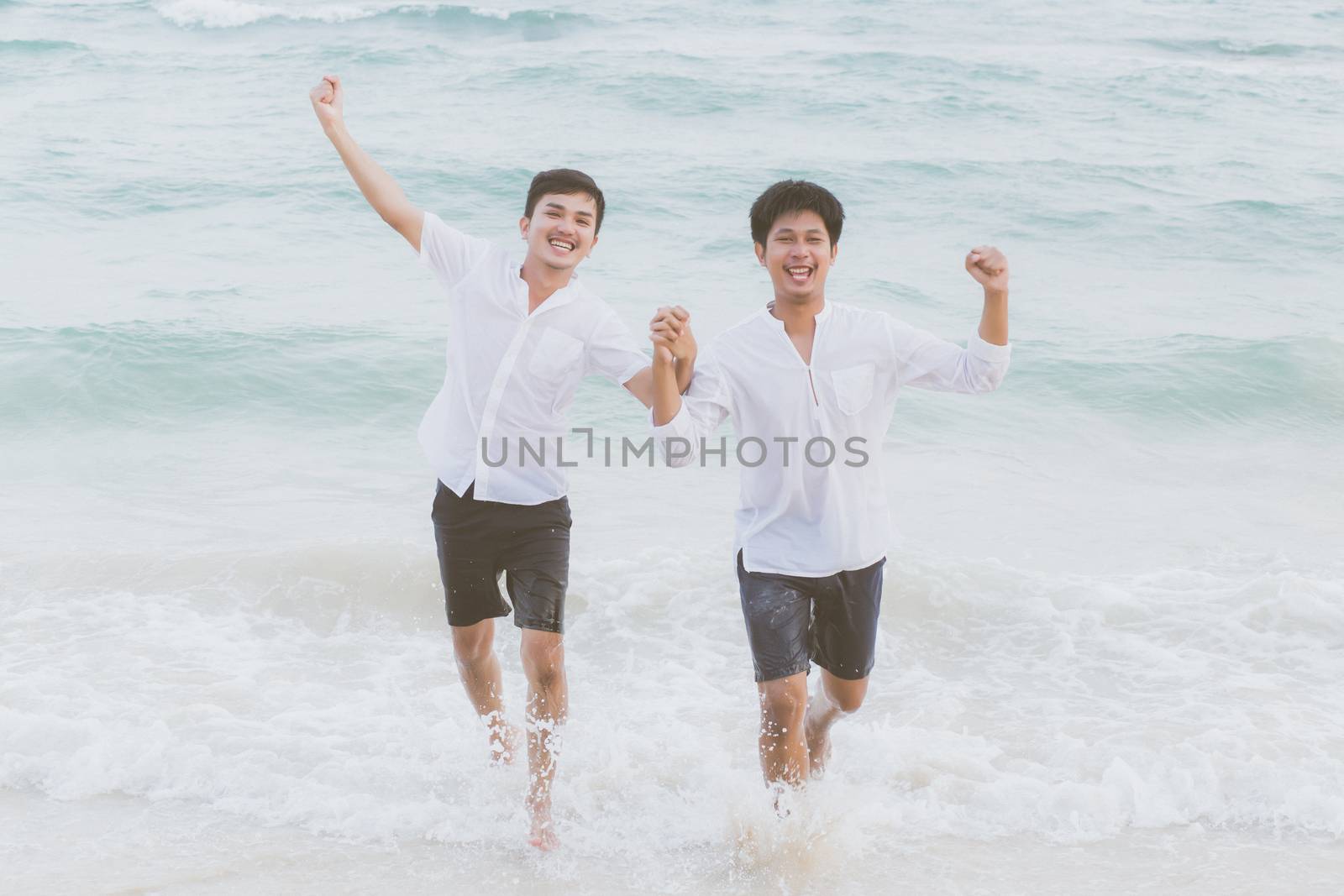 Homosexual portrait young asian couple running with cheerful together on beach in summer, asia gay going tourism for leisure and relax with happiness in vacation at sea, LGBT legal concept.