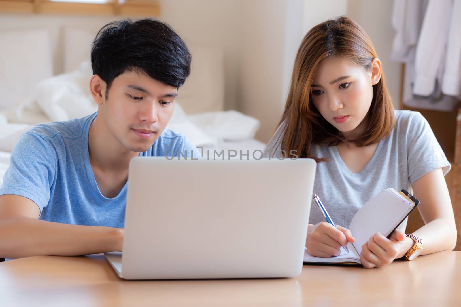 Beautiful young asian couple calculate expenses finance with lap by nnudoo