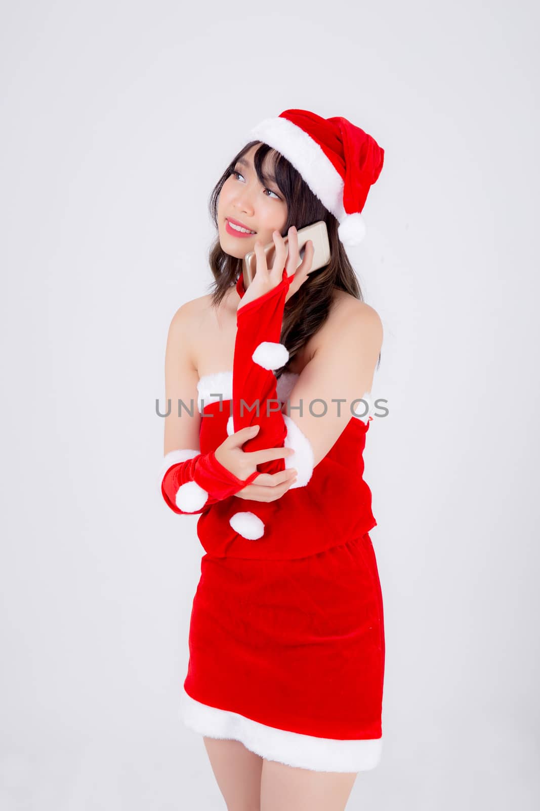 Beautiful portrait young asian woman in Santa talking smartphone in xmas day isolated on white background, asia girl speak and conversation with phone in Christmas holiday, communication concept.