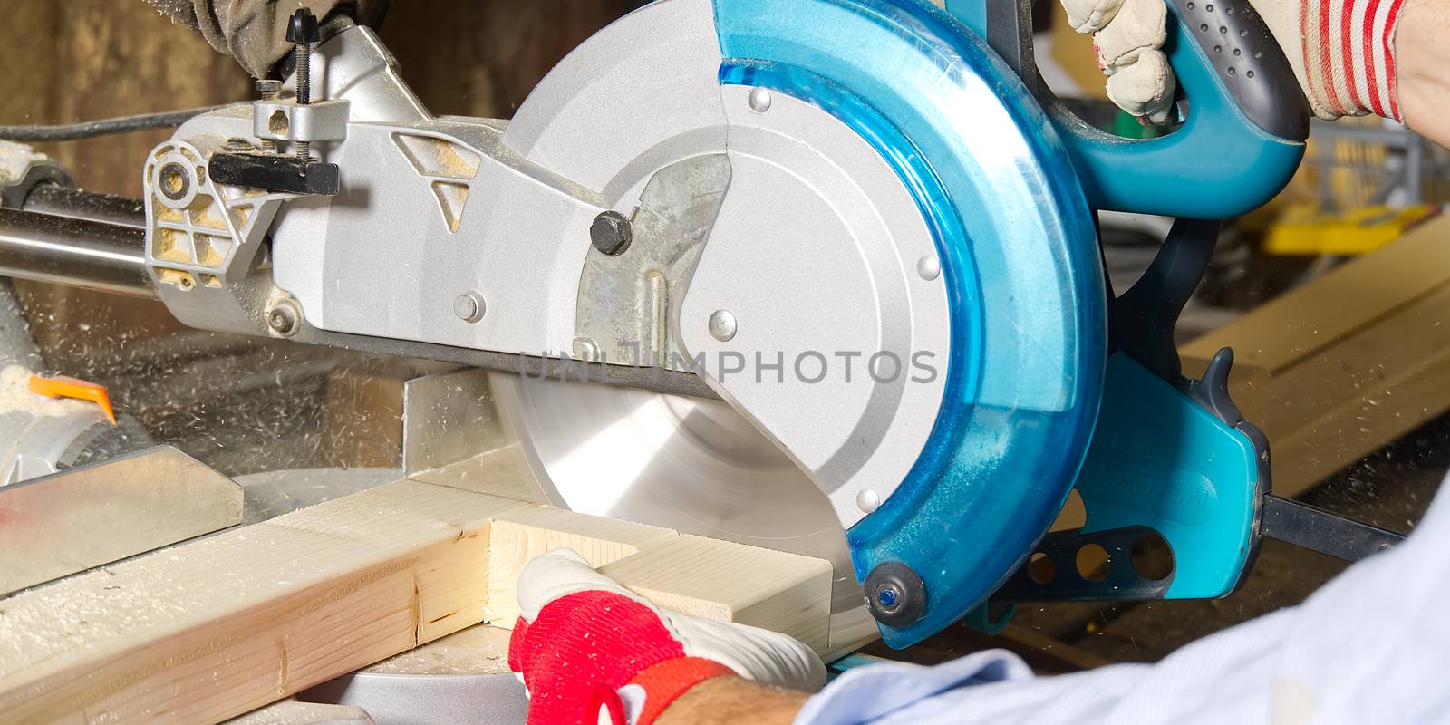 Carpenter work with circular saw for cutting wood bar, the man sawed bars, construction and home renovation. Carpenter work concept by PhotoTime