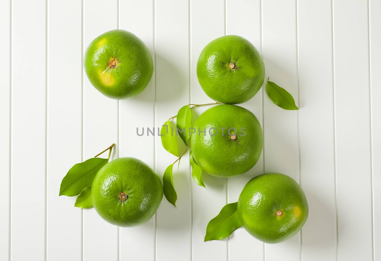 Five whole sweetie fruits (green grapefruits, pomelits) and leaves