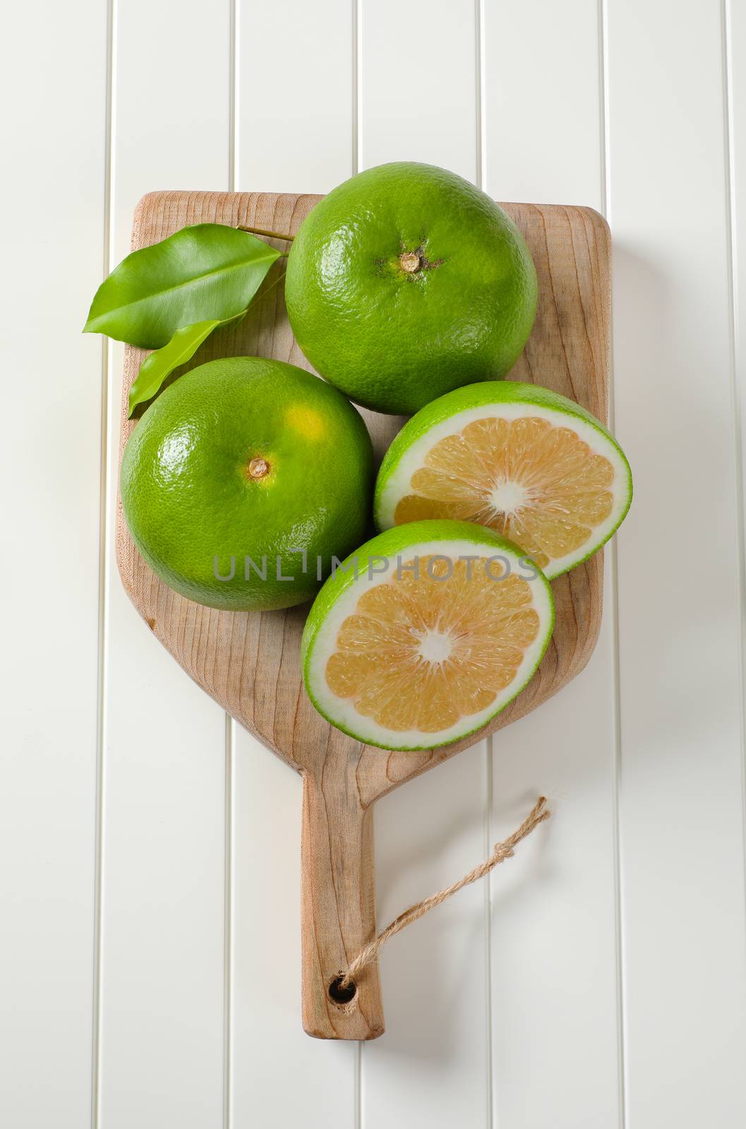 Sweetie fruits (green grapefruits, pomelits) on cutting board