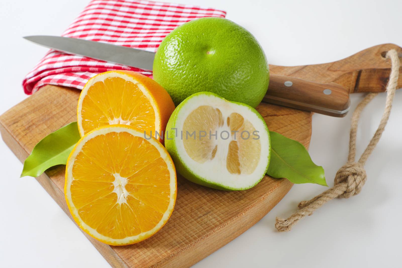 Green grapefruits and halved orange by Digifoodstock
