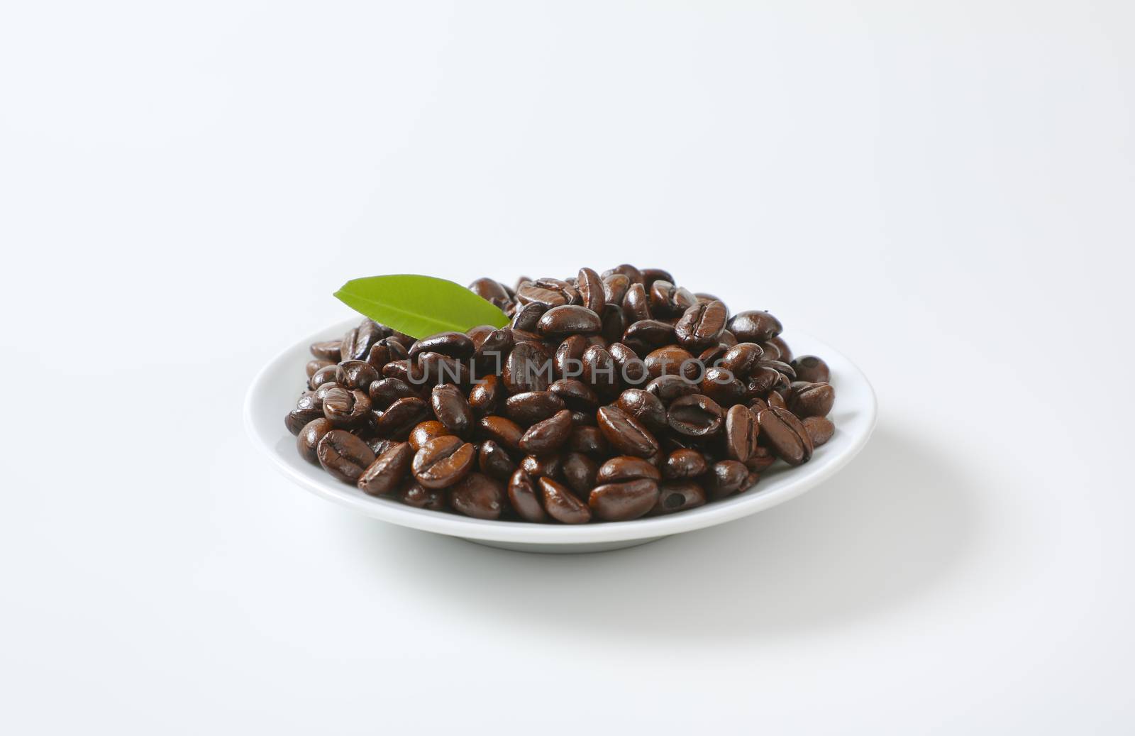 Roasted coffee beans on white plate