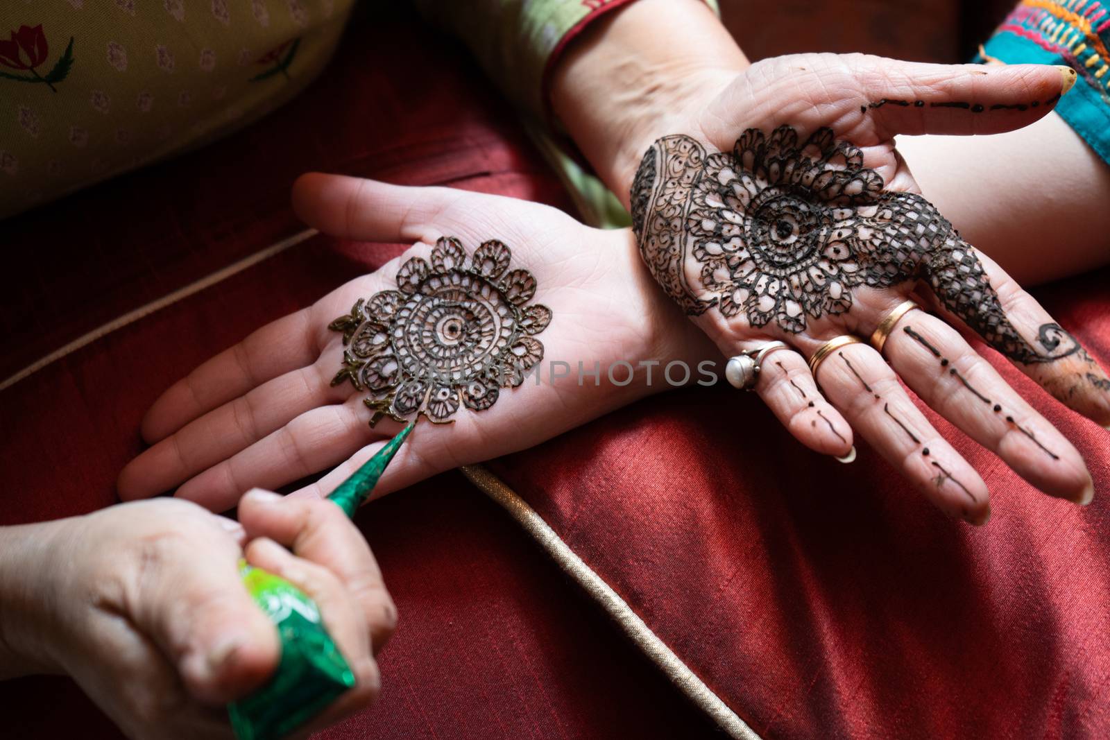 Top down video of a woman copying the mehndi henna tattoo from one hand to the other in preparation of the hindu festival of teej, karwachauth, diwali dussera or a marriage function by Shalinimathur