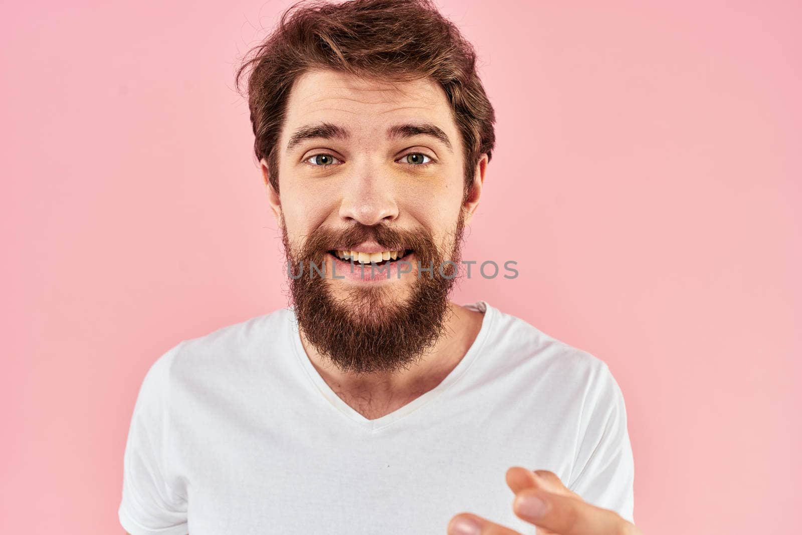 Bearded man white t-shirt cropped view lifestyle studio pink background. High quality photo