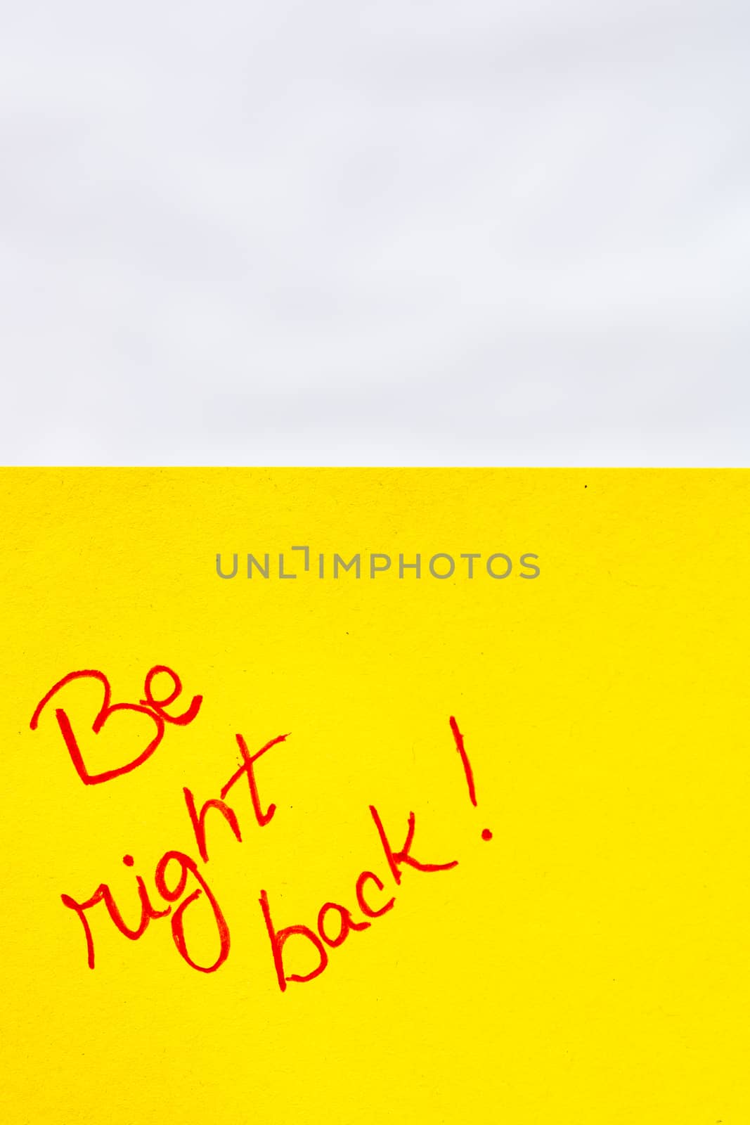 Be right back handwriting text close up isolated on orange paper with copy space. Writing text on memo post reminder