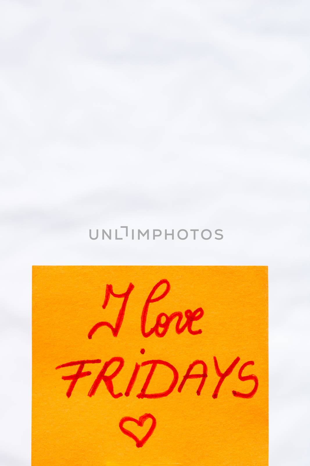 I love fridays handwriting text close up isolated on orange paper with copy space.