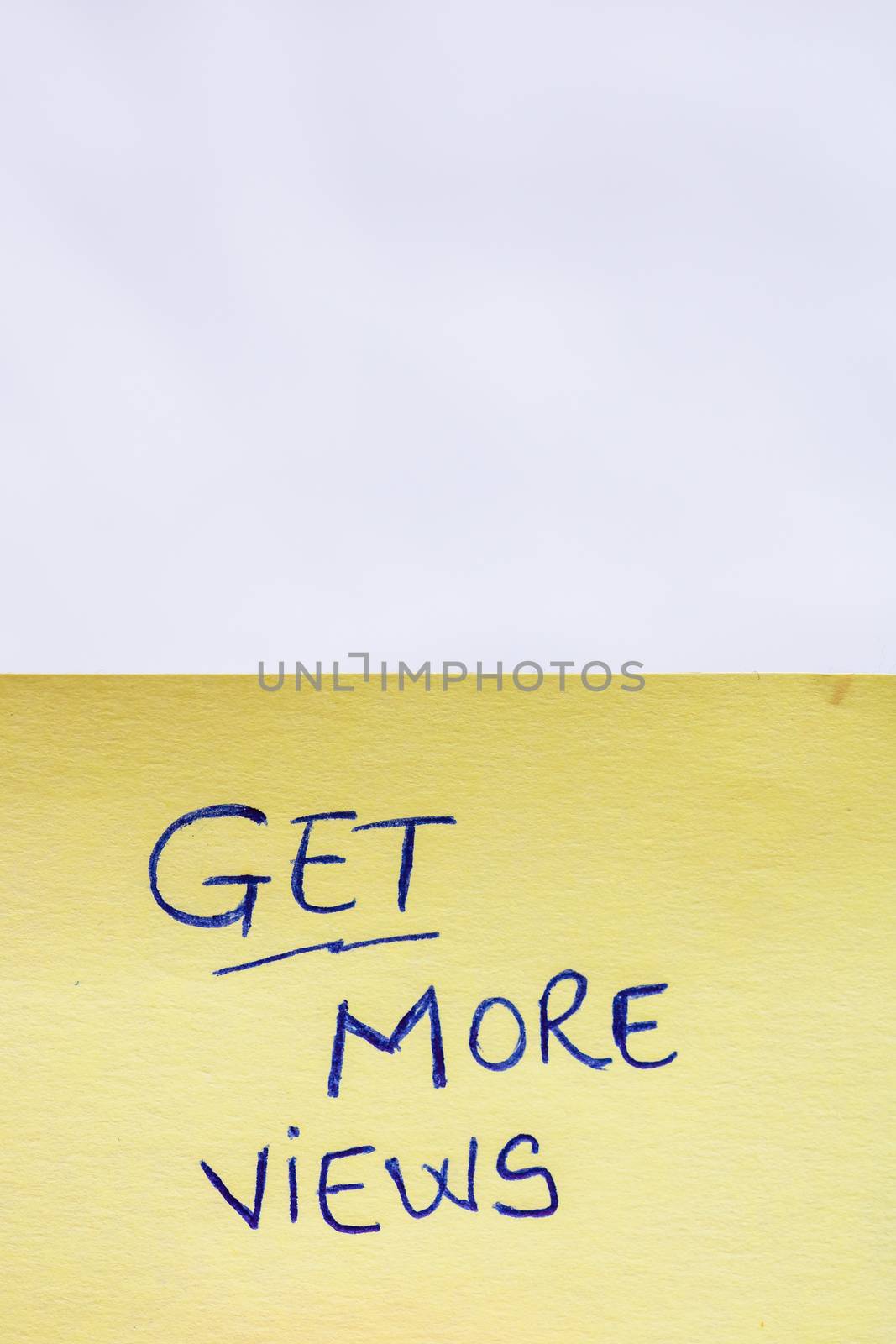 Get more views handwriting text close up isolated on yellow paper with copy space.