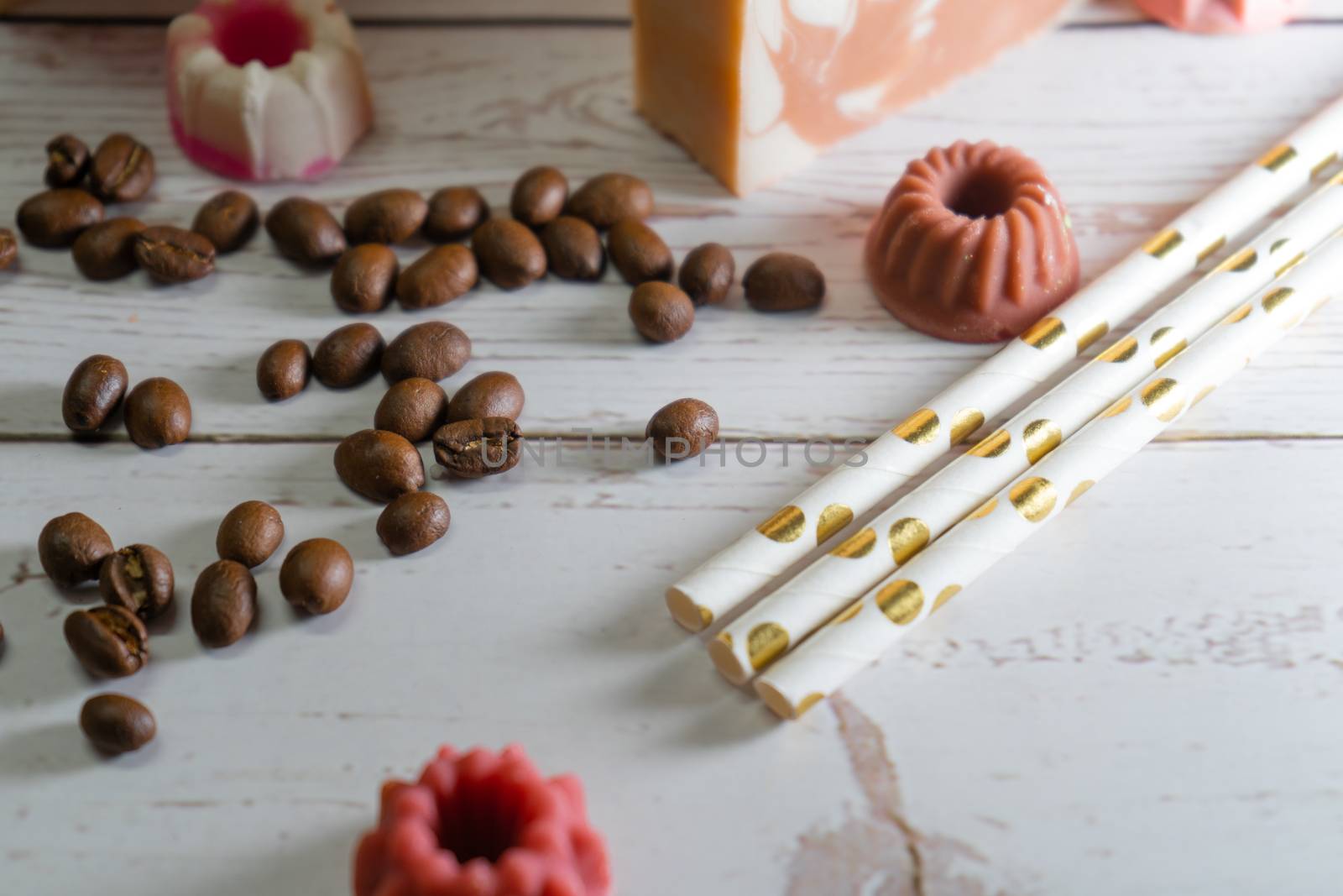 tilted shot showing coffee beans, small candies straws on a beautiful wooden background showing a cafe bakery or small restaurant operation by Shalinimathur