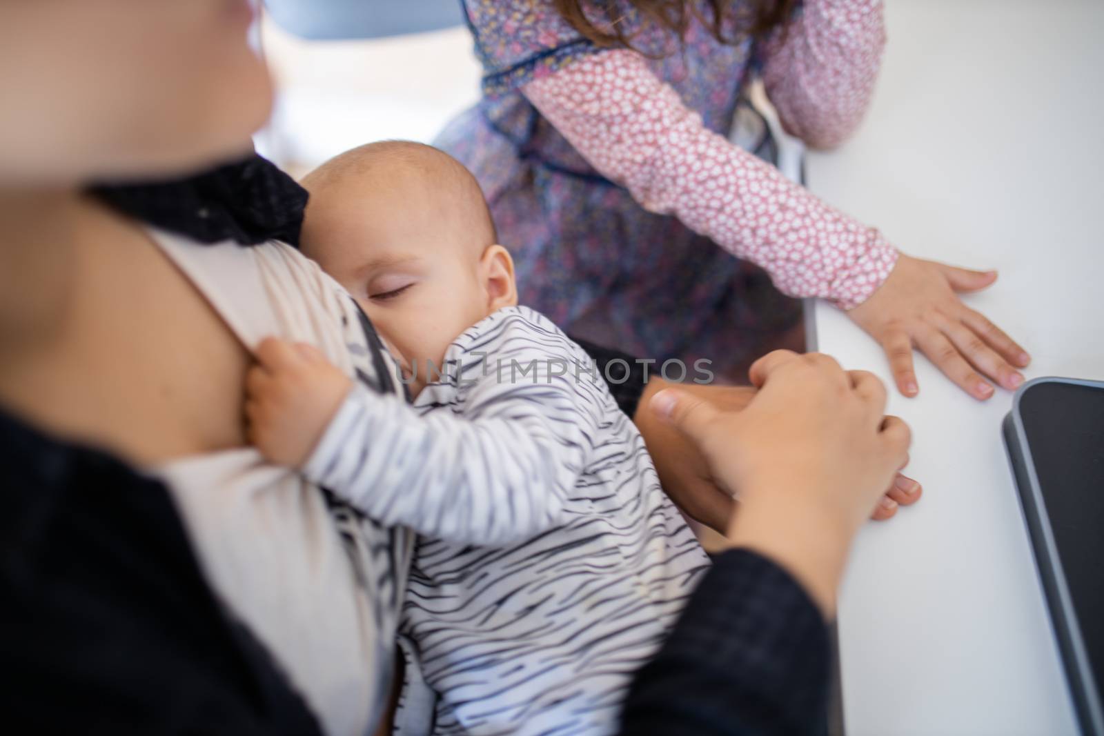 Sleeping baby resting in the arms of her mother while pulling her shirt by Kanelbulle