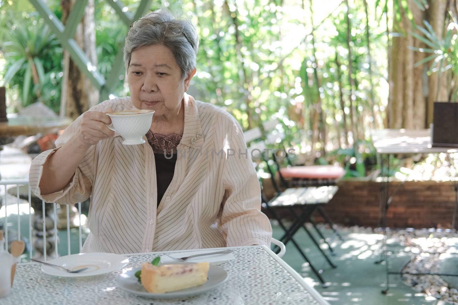old elderly senior elder woman drinking hot mocha coffee tea at restaurant. mature retirement lifestyle
