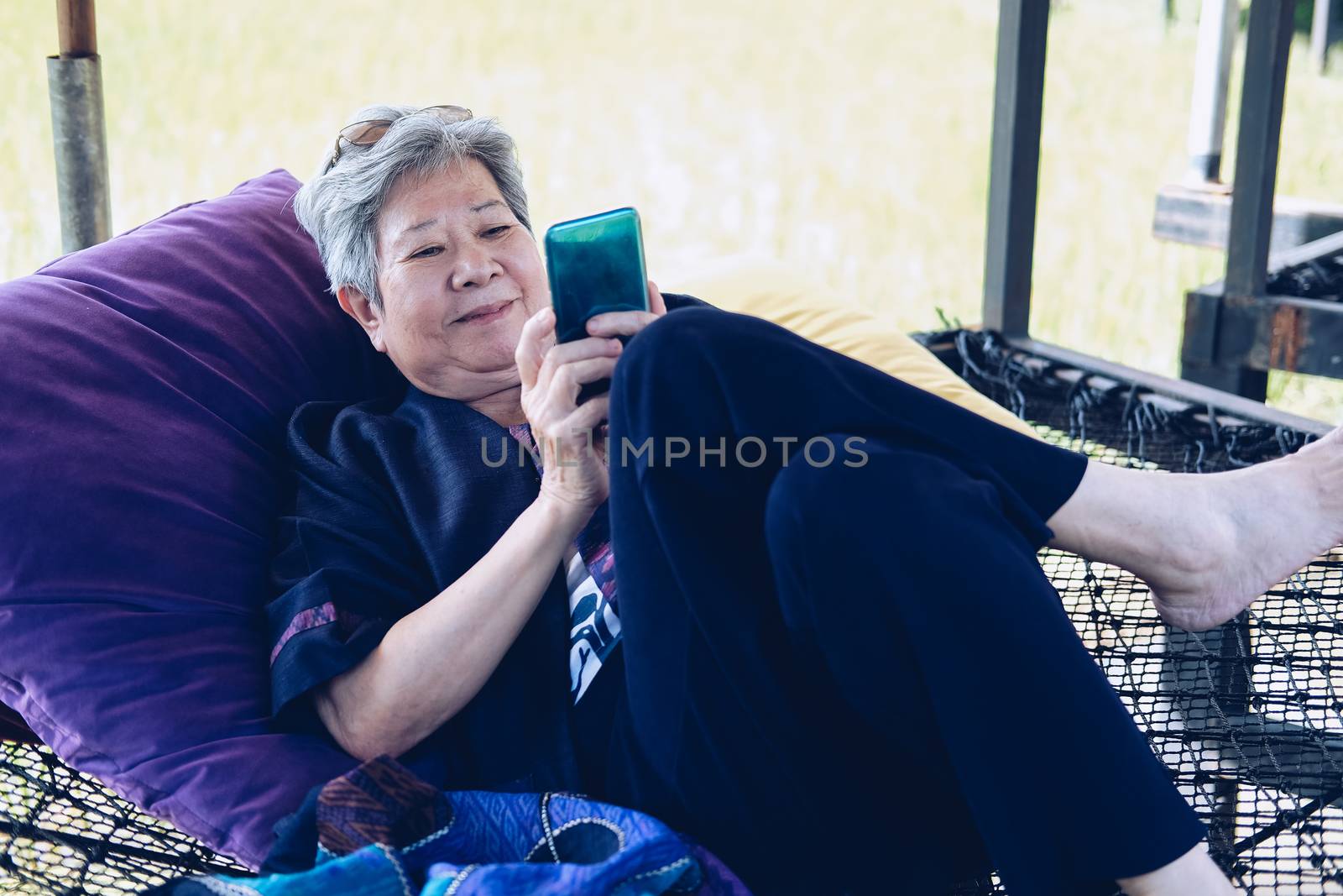 asian elder senior woman using mobile smart phone. elderly female holding cellphone. mature retirement lifestyle