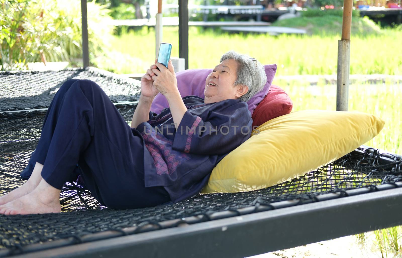 asian elder senior woman using mobile smart phone. elderly female holding cellphone. mature retirement lifestyle