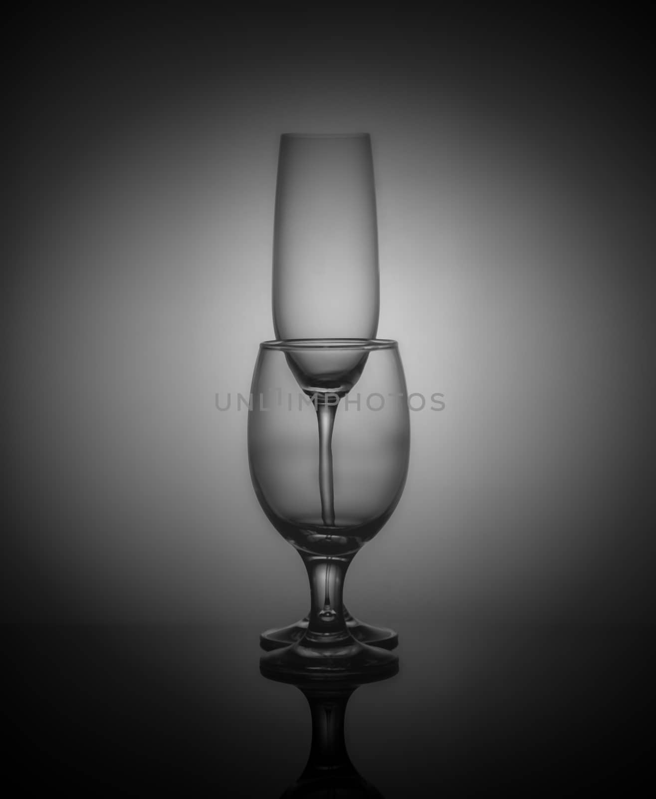 empty drink glasses placed one after another on dark background with back light.