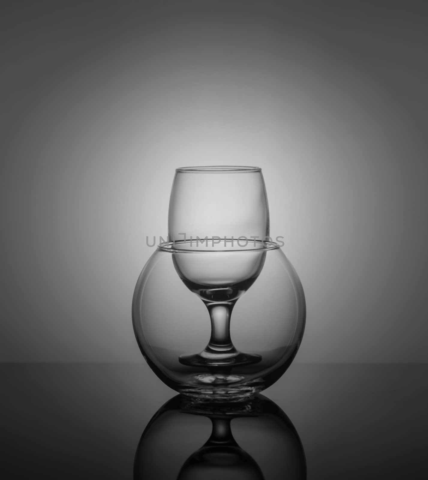 empty drink glasses placed one after another on dark background with back light by galinasharapova