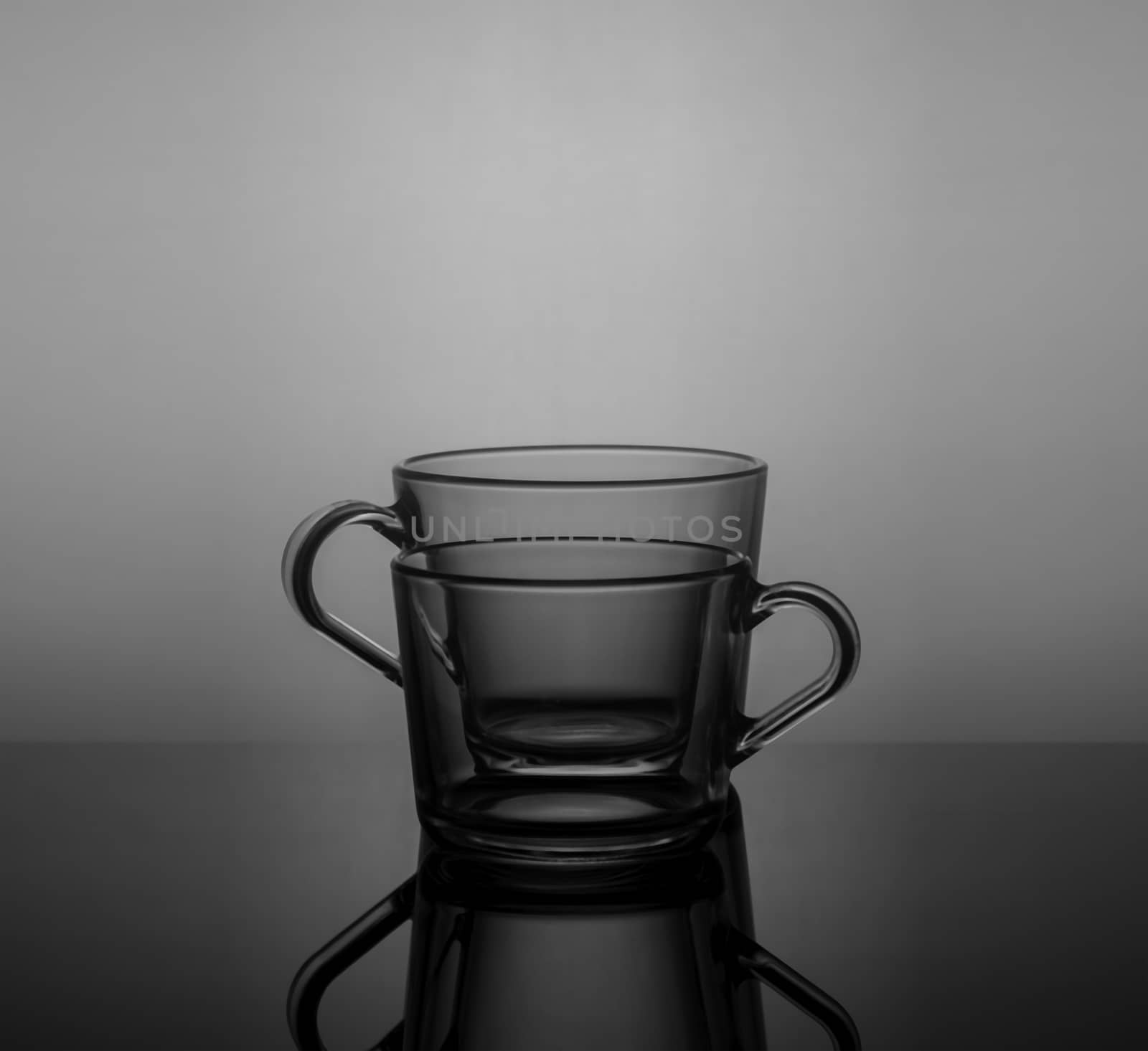 Empty tea cups on dark background with back light.